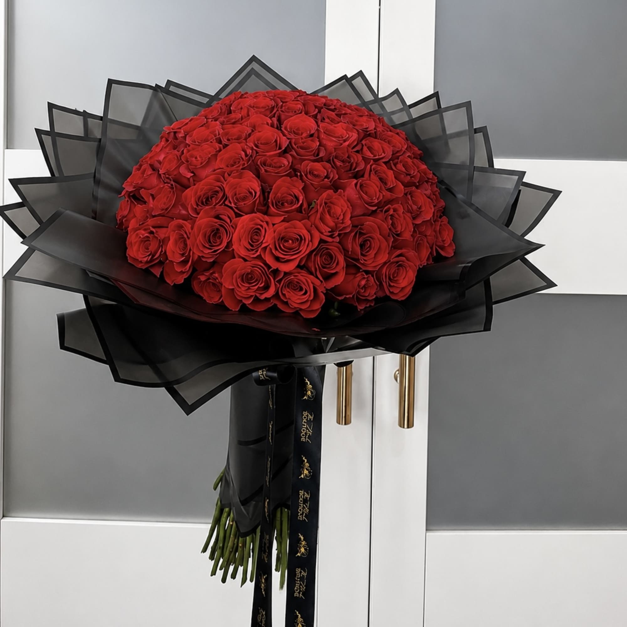 Large bouquet of red roses wrapped in black paper