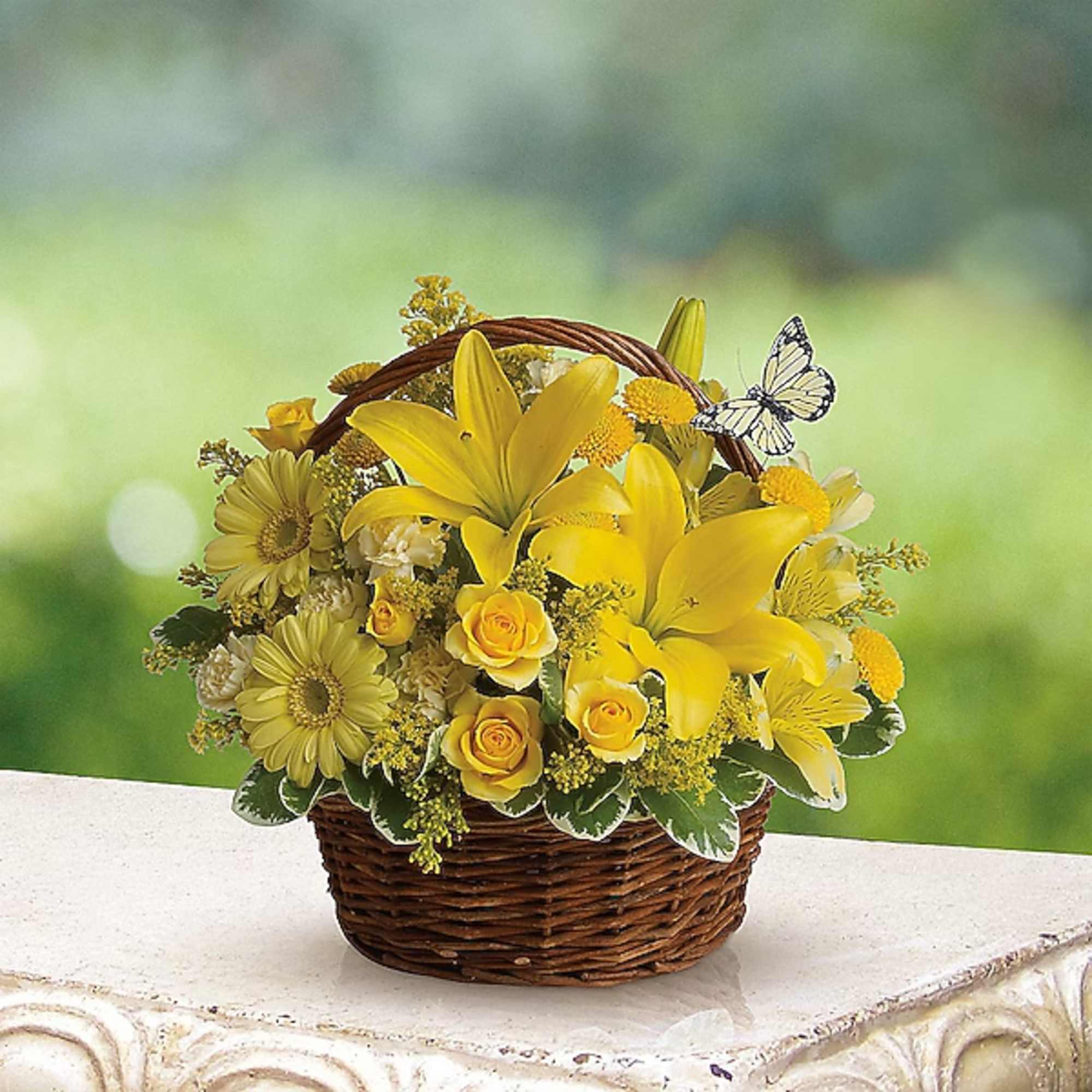 Yellow floral basket arrangement with lilies, daisies, and roses in a wicker basket