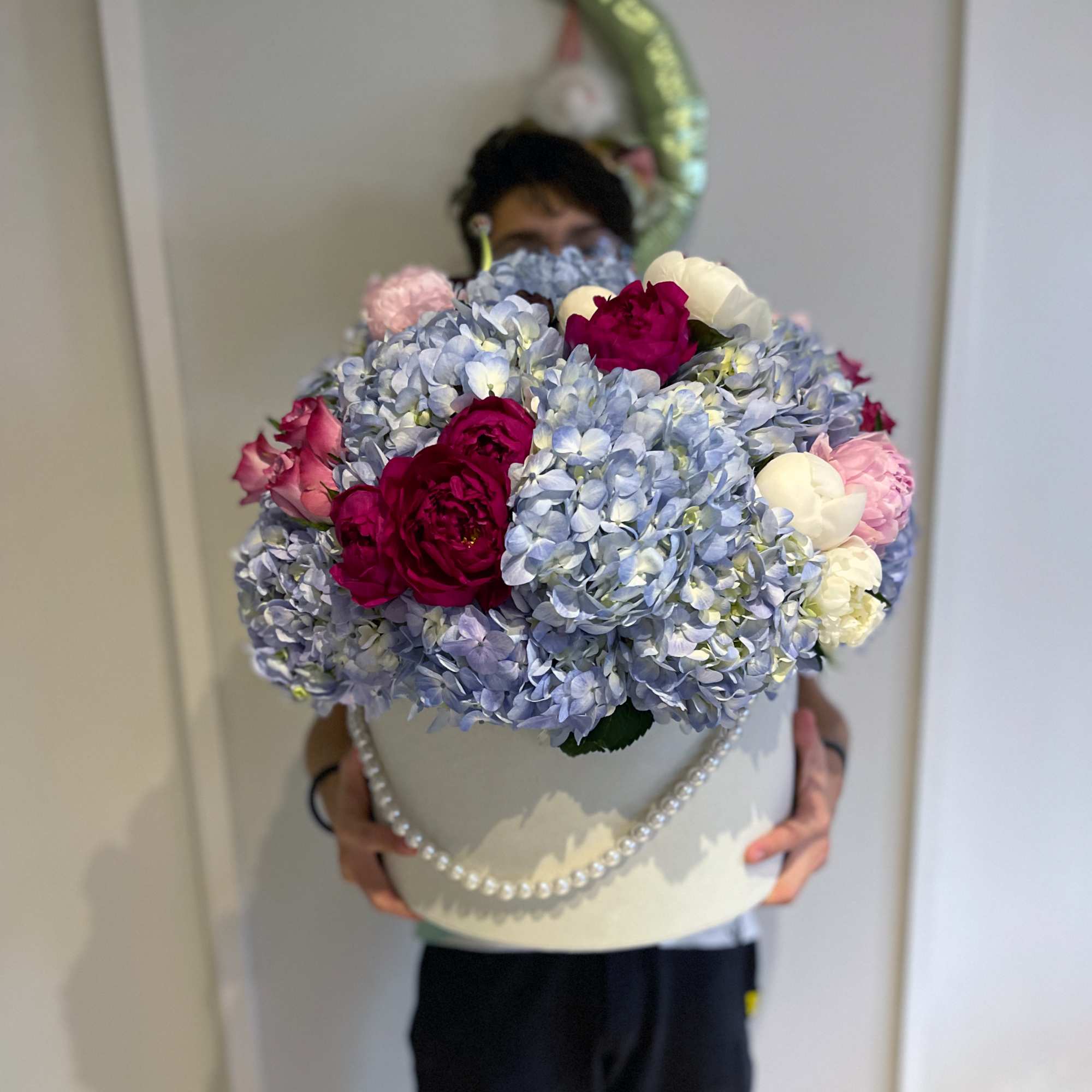 Large hatbox arrangement of blue hydrangeas with pink and white roses