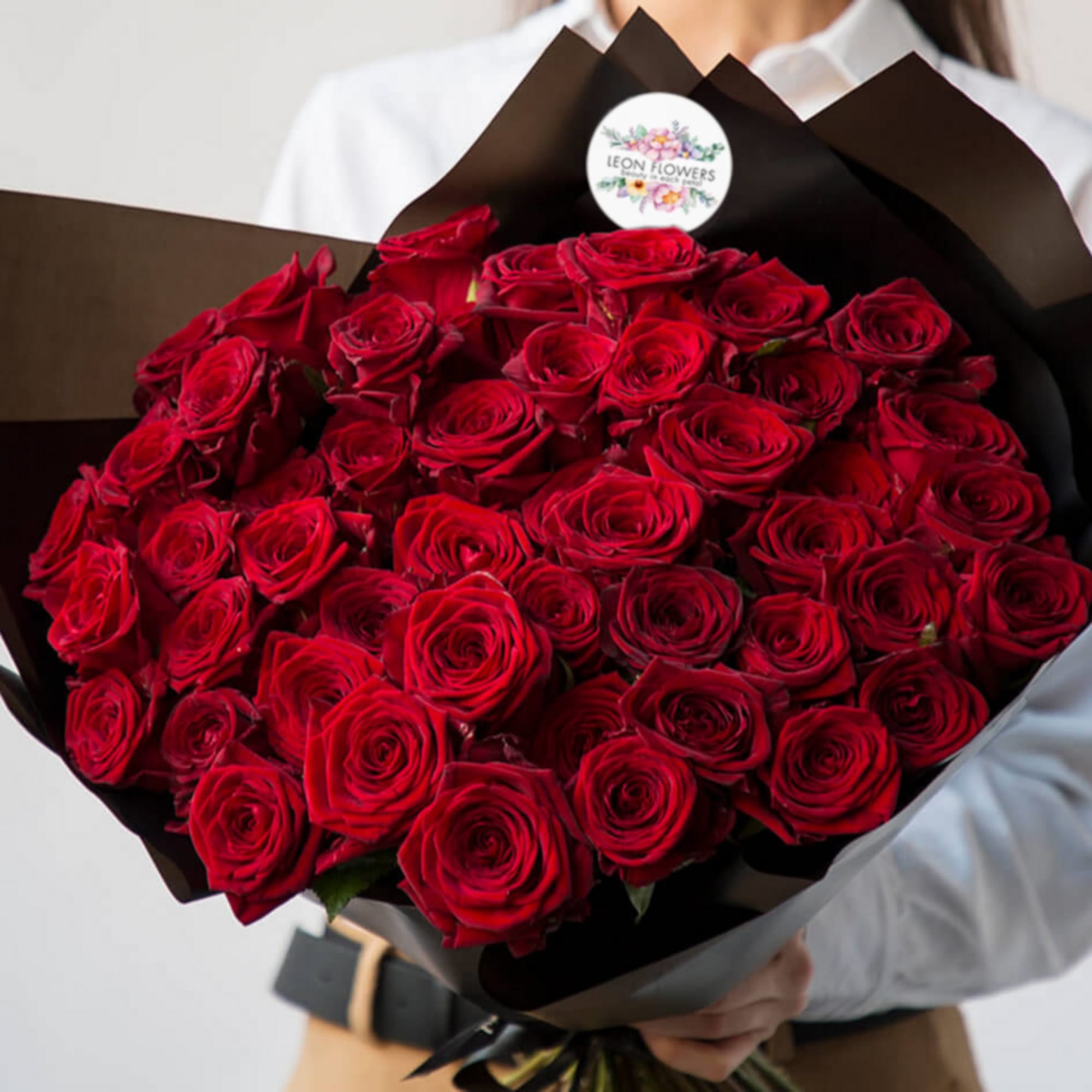 Large bouquet of red roses wrapped in black paper