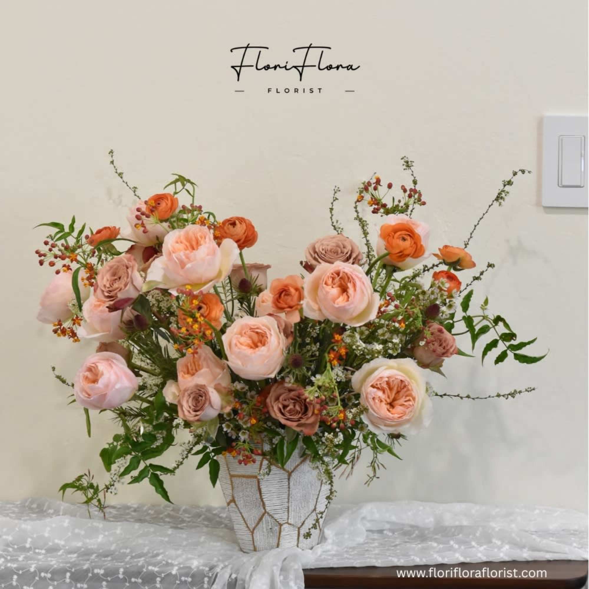This arrangement is a celebration of warm peach and orange tones, radiating