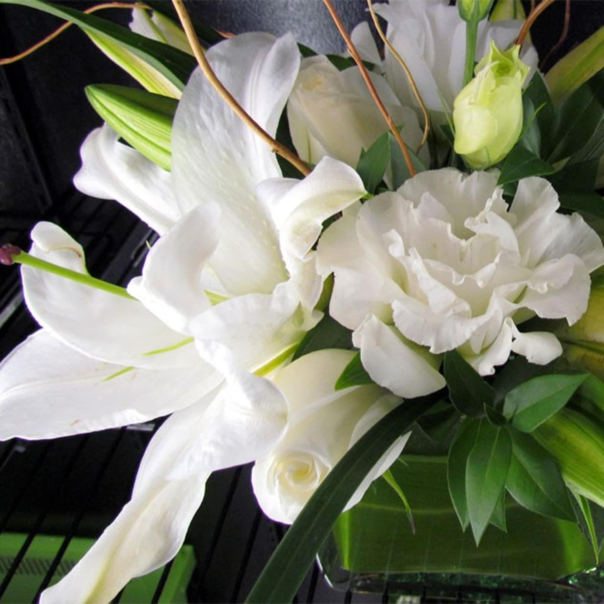 White lilies and carnations in a glass vase