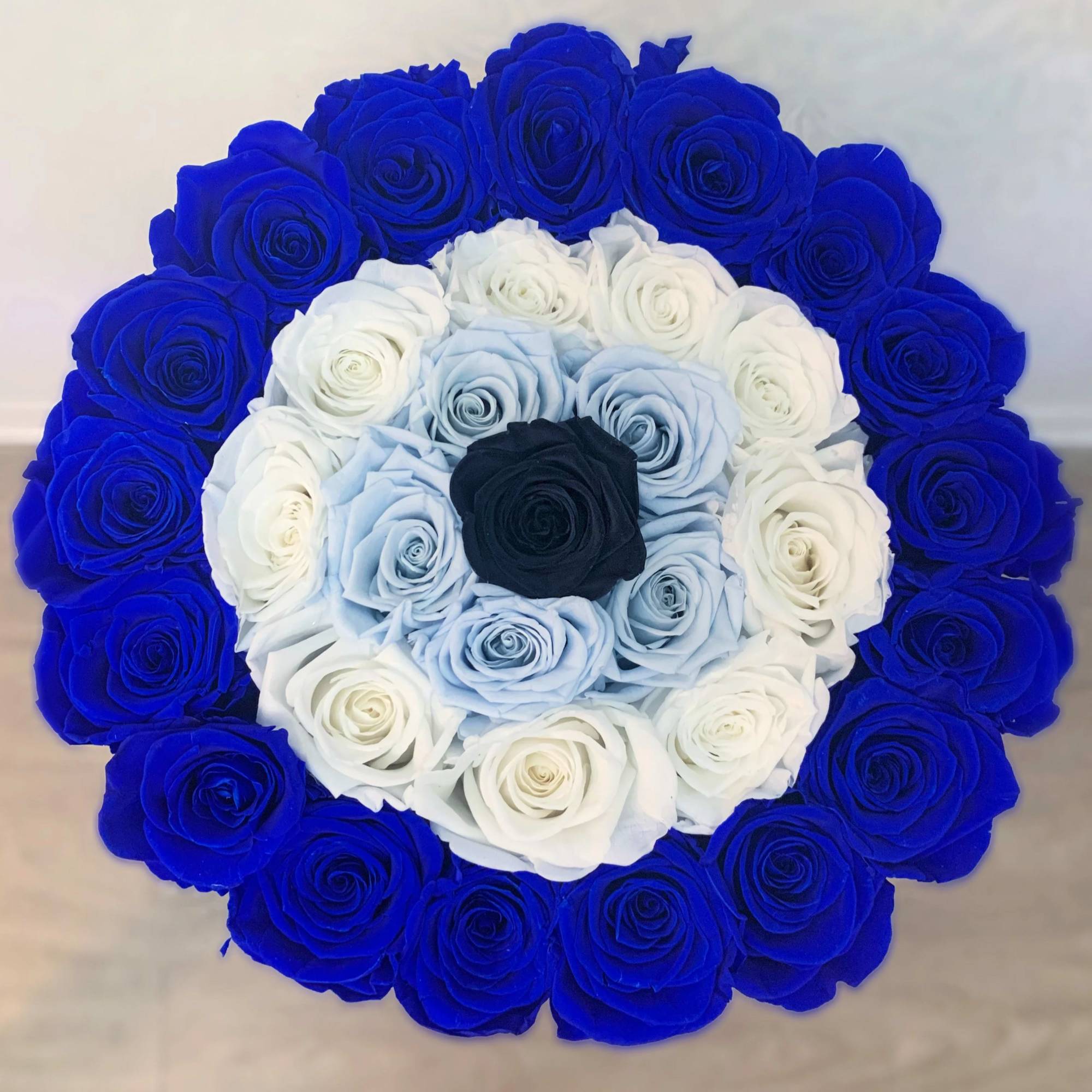 Round bouquet of blue, white, and black roses