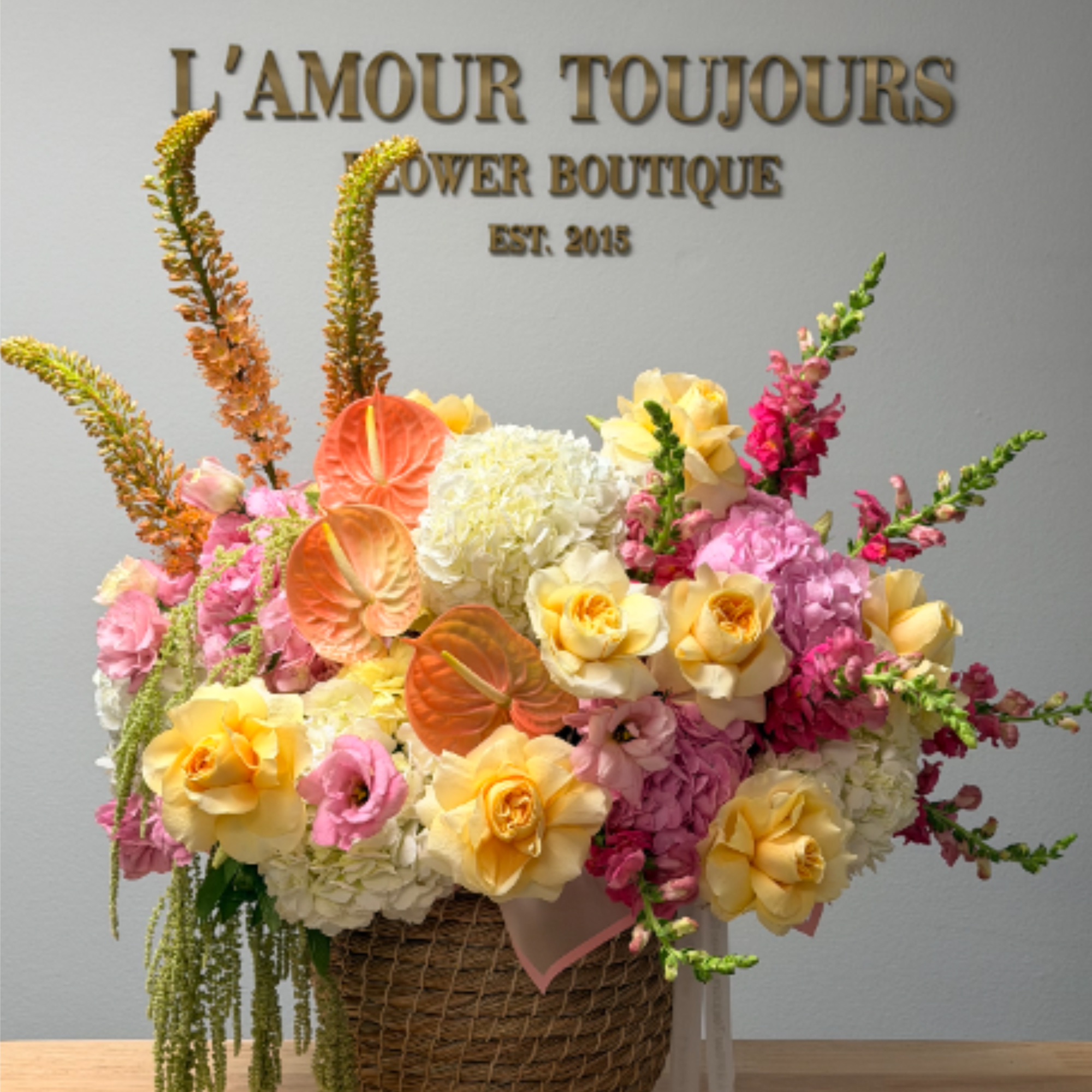 An airy, celebratory bouquet overflowing from a woven basket-this Summer vibe basket