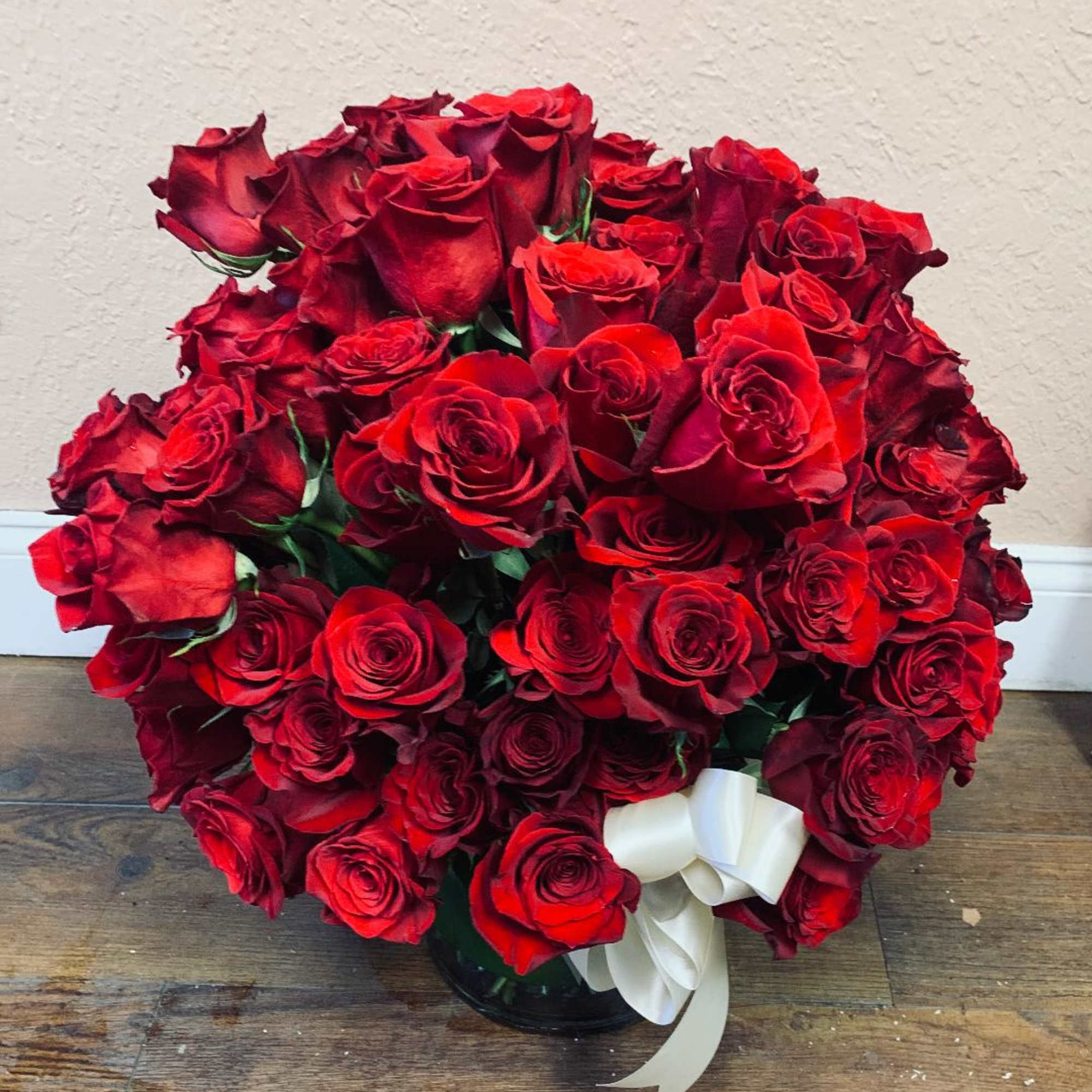 Bouquet of red roses in a glass vase with a white ribbon, photo 2 of 3