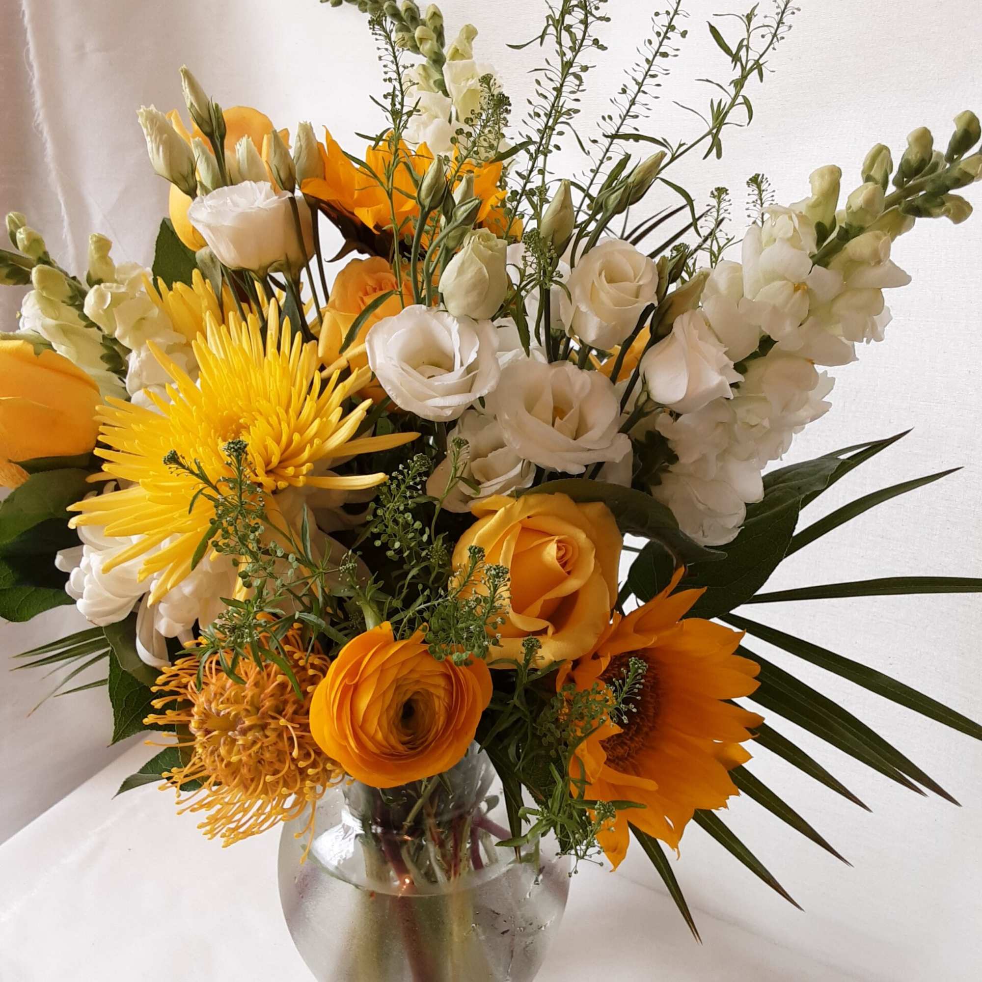 Yellow and white mixed bouquet in a clear glass vase