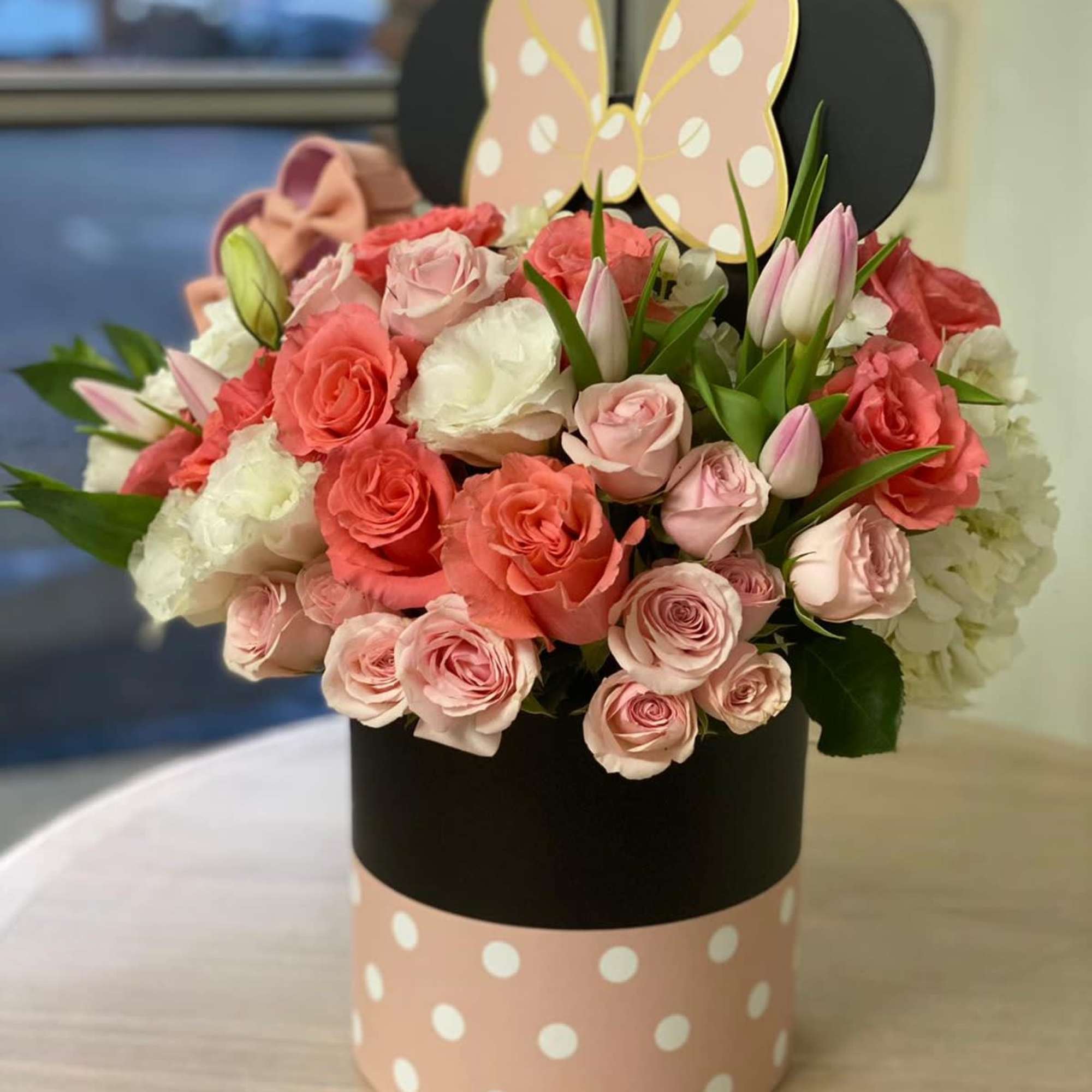 Pink and white roses with tulips in a polka-dot hatbox