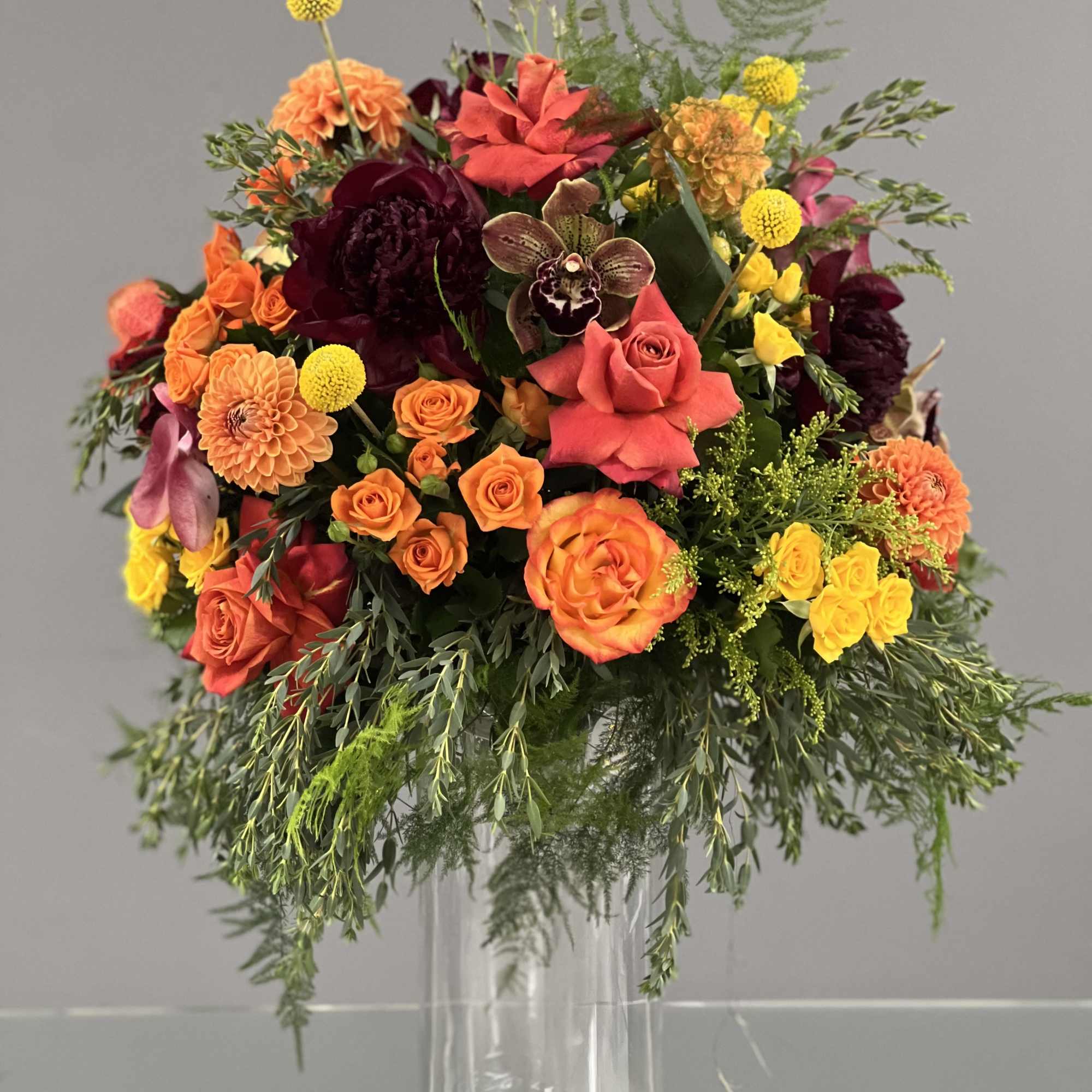 Mixed orange, pink, and yellow bouquet in a clear glass vase