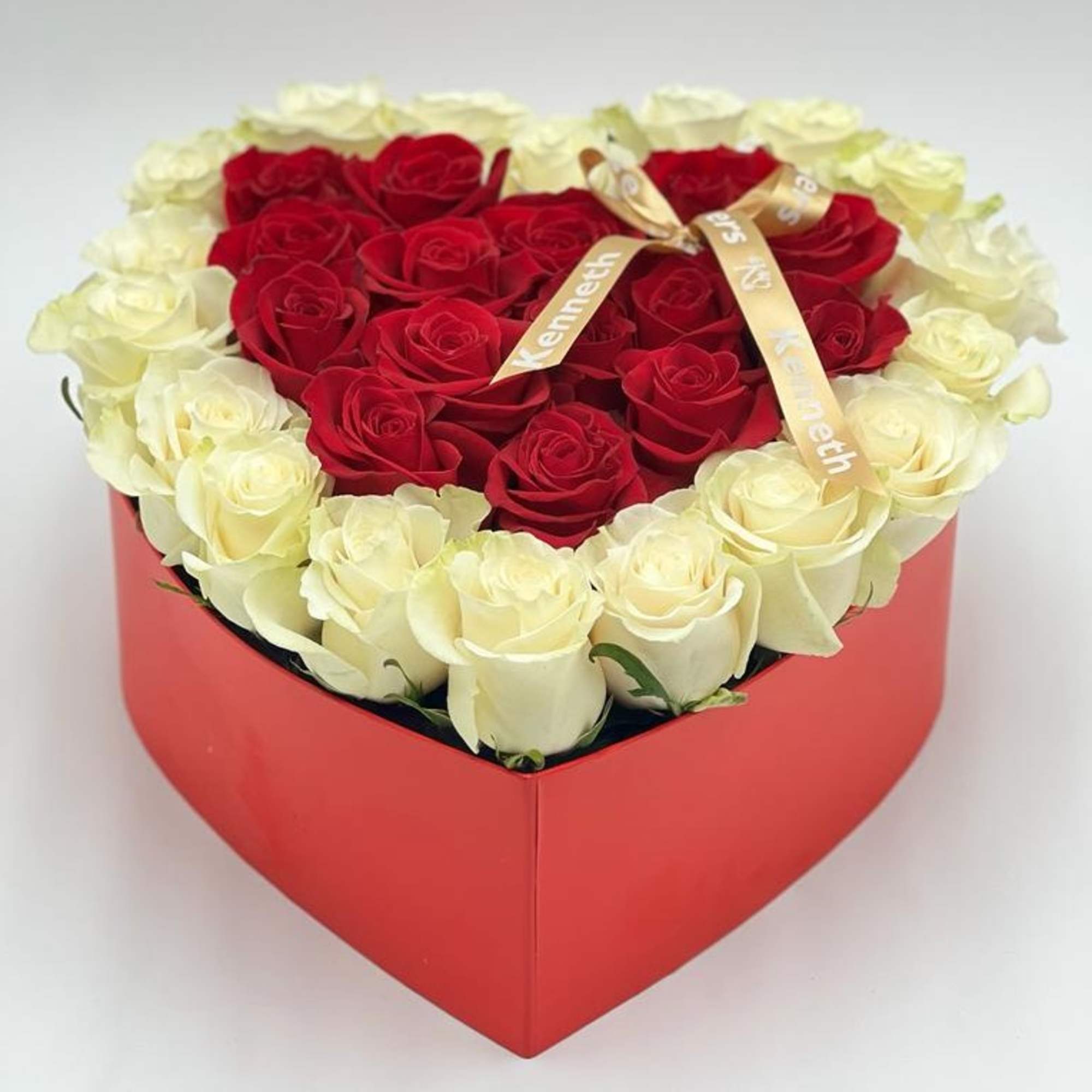 Heart-shaped box of red and white roses with a ribbon