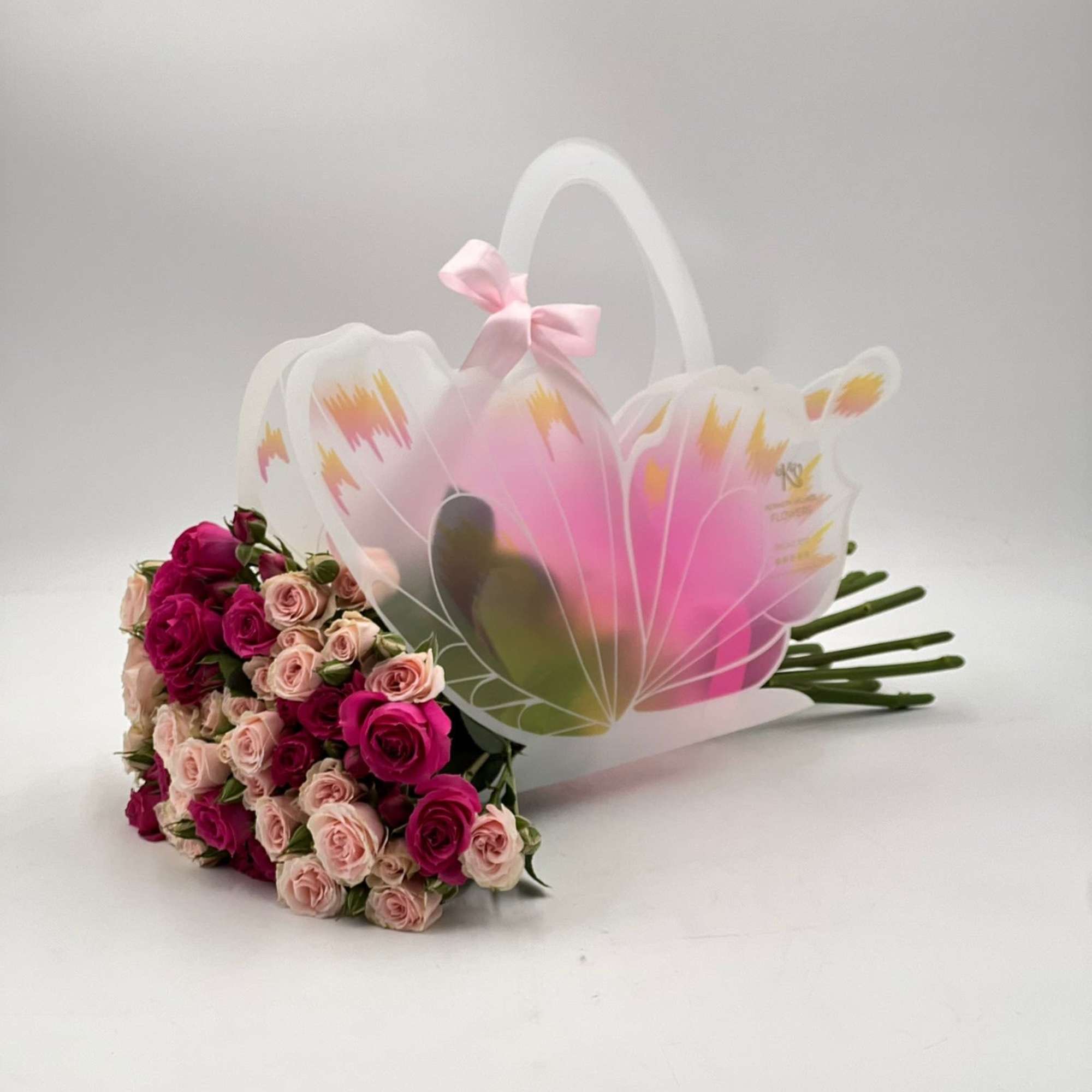 Bouquet of pink and blush roses with a translucent butterfly handle wrap
