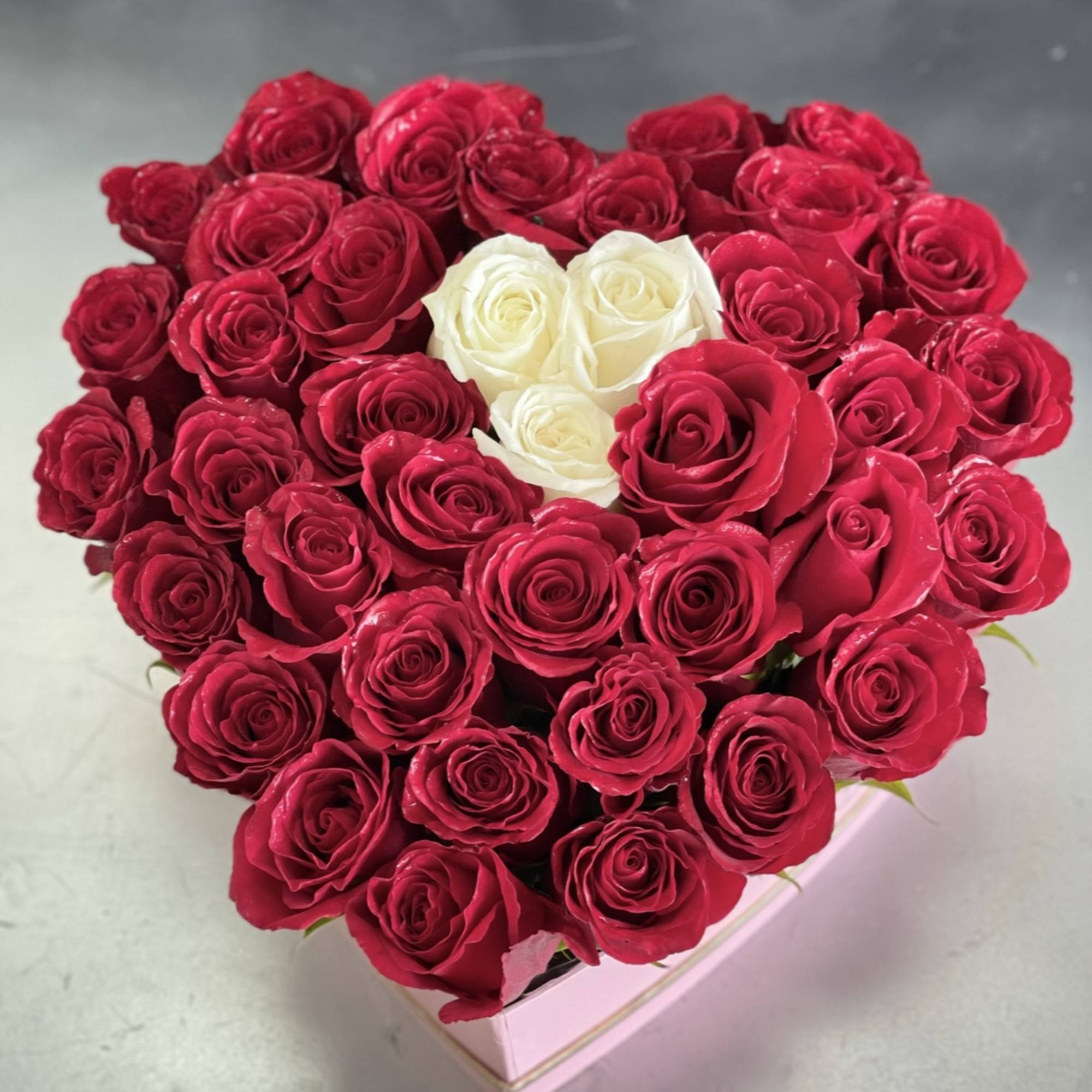 A bold heart-shaped display of 50 fresh roses makes an unforgettable anniversary