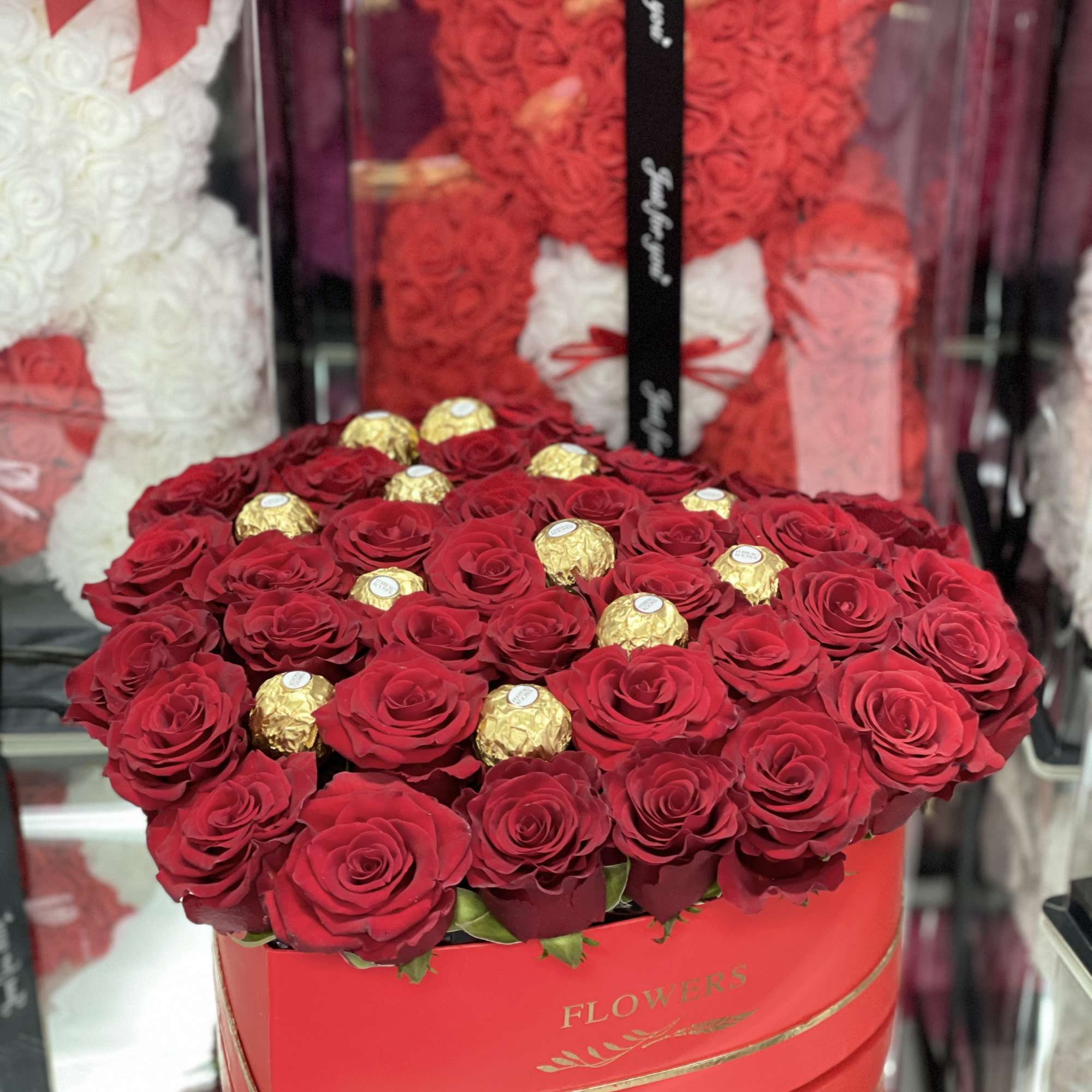 Heart-shaped box of red roses with gold-wrapped chocolates