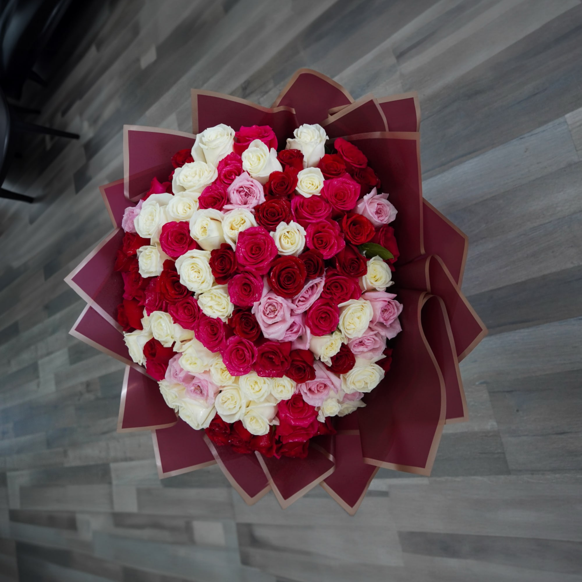 A lush dome of red, pink and white roses wrapped in bright