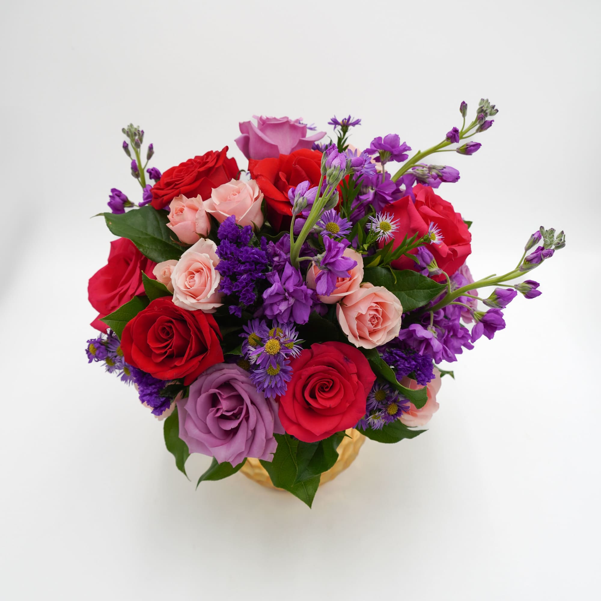 Bouquet of red, pink, and purple roses with small purple filler flowers