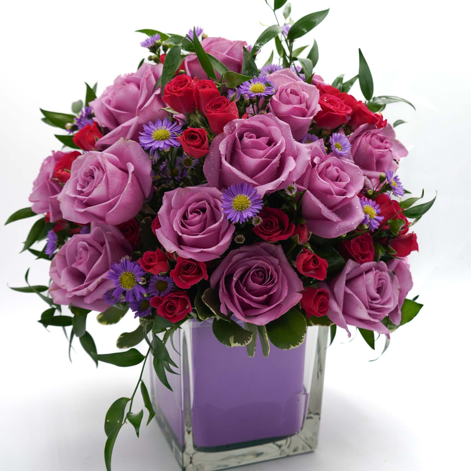 Pink and red rose bouquet in a square glass vase