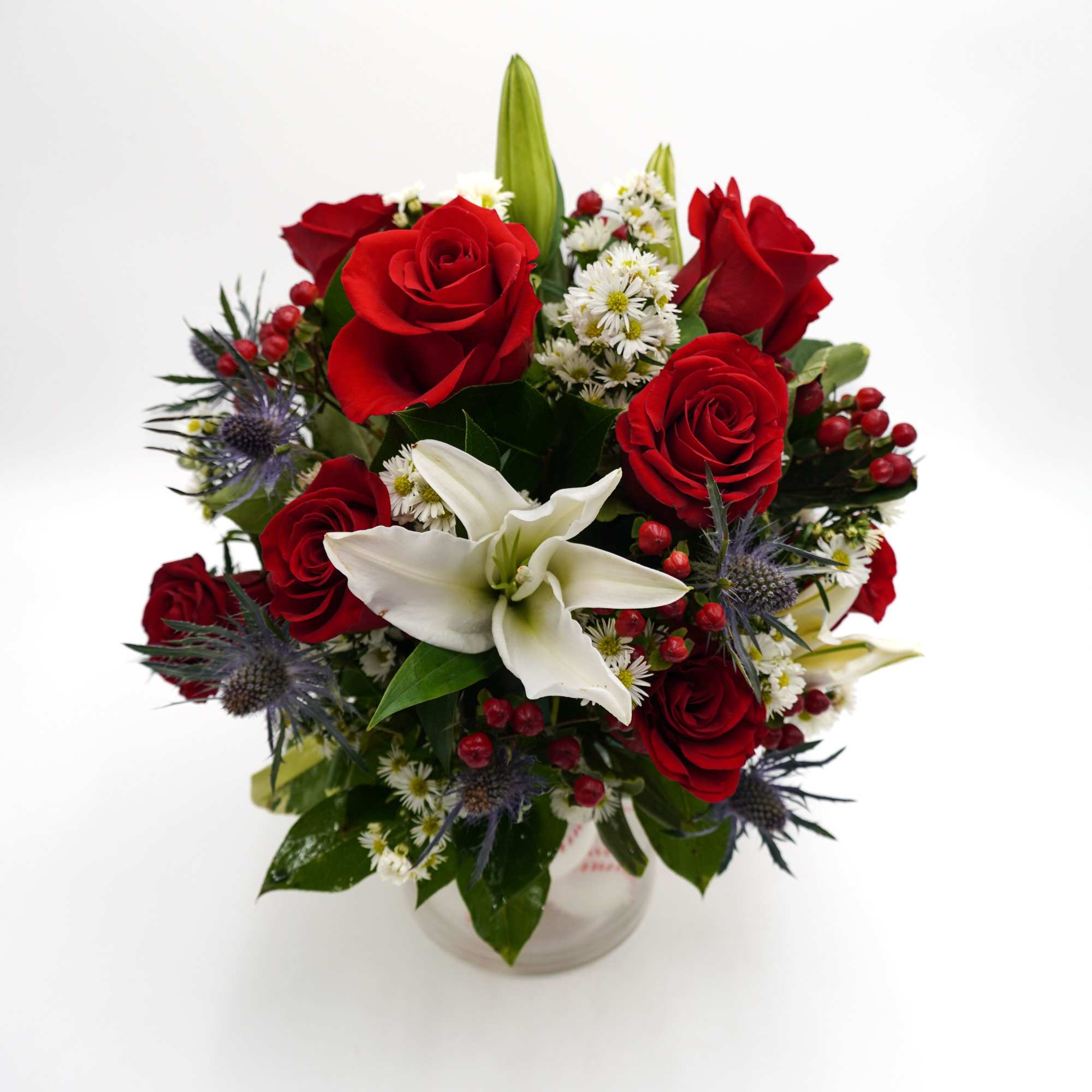 Red roses and white lilies in a clear glass vase