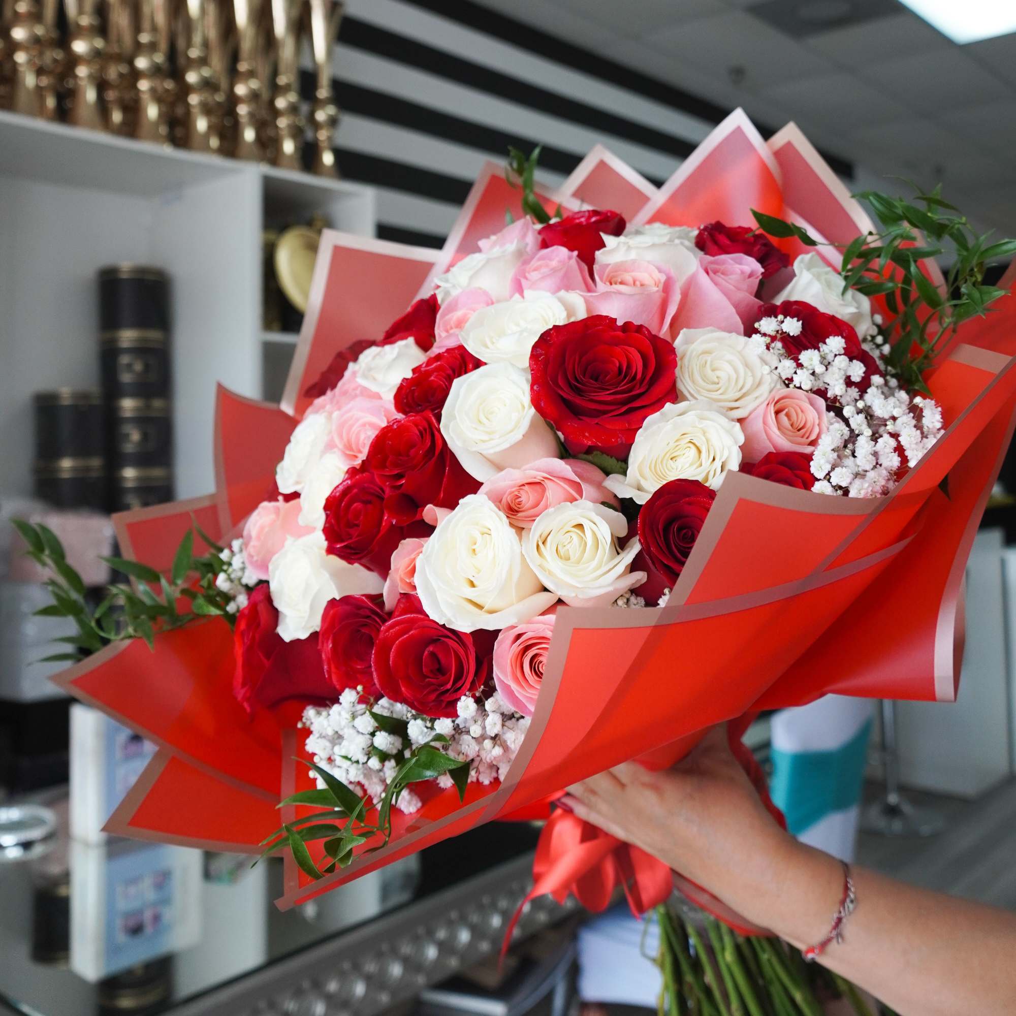 A lush dome of red, pink and white roses wrapped in bright