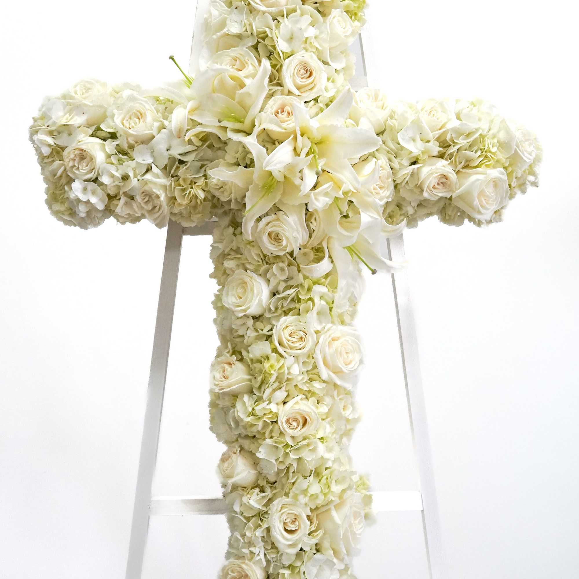 White floral cross on a stand with roses and lilies, photo 2 of 2