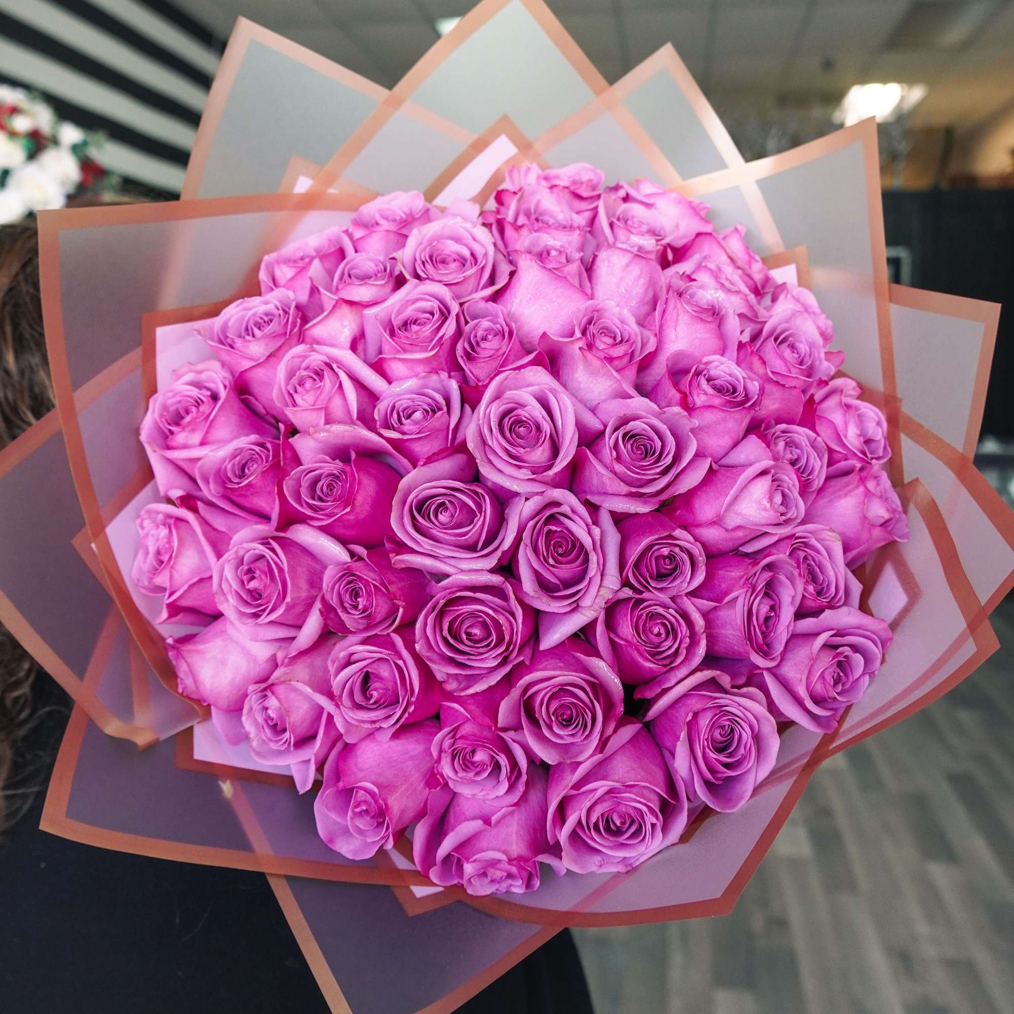 Bouquet of pink roses wrapped in translucent paper