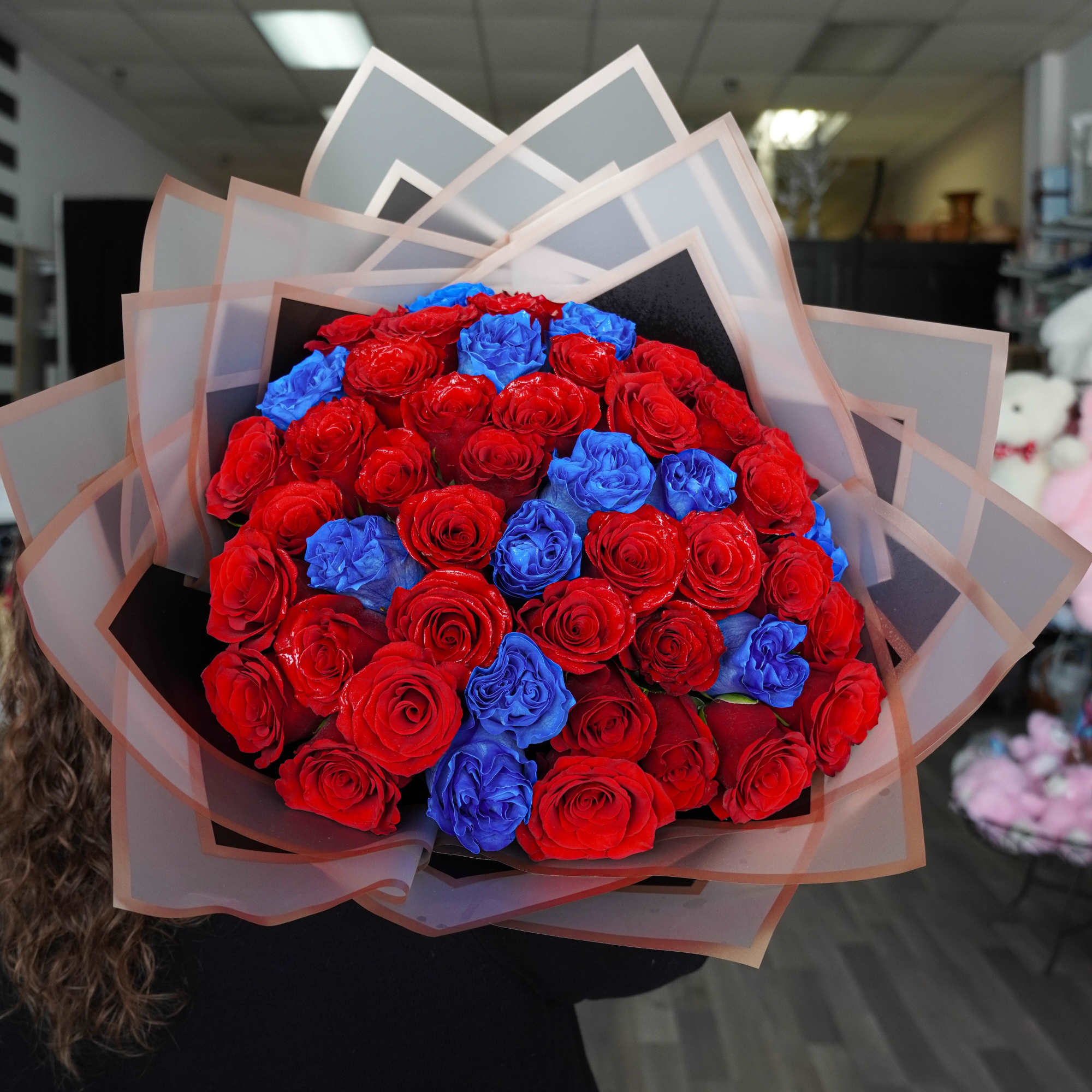 Bouquet of red and blue roses wrapped in layered paper