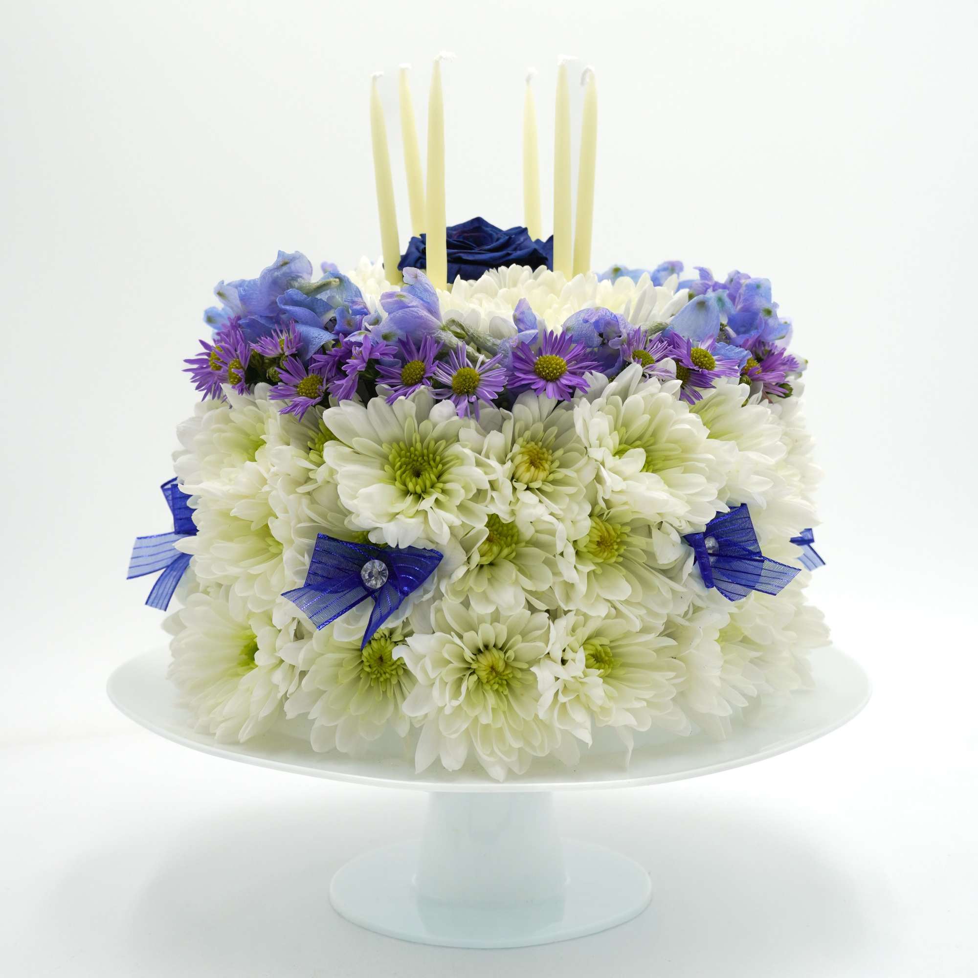A floral "cake" fashioned from dense white chrysanthemums with a halo of