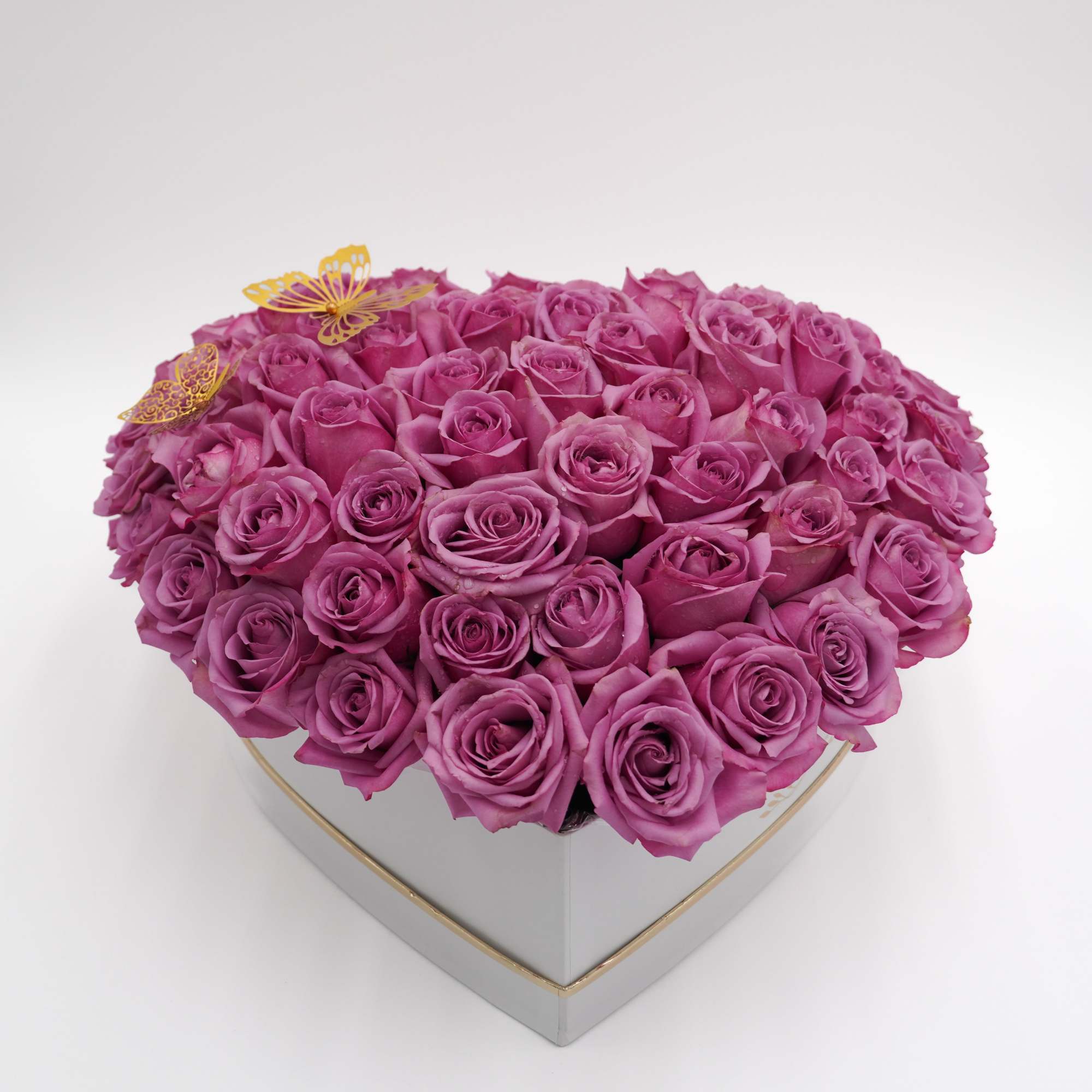 A dense heart-shaped box filled with 70 premium lavender roses creates an