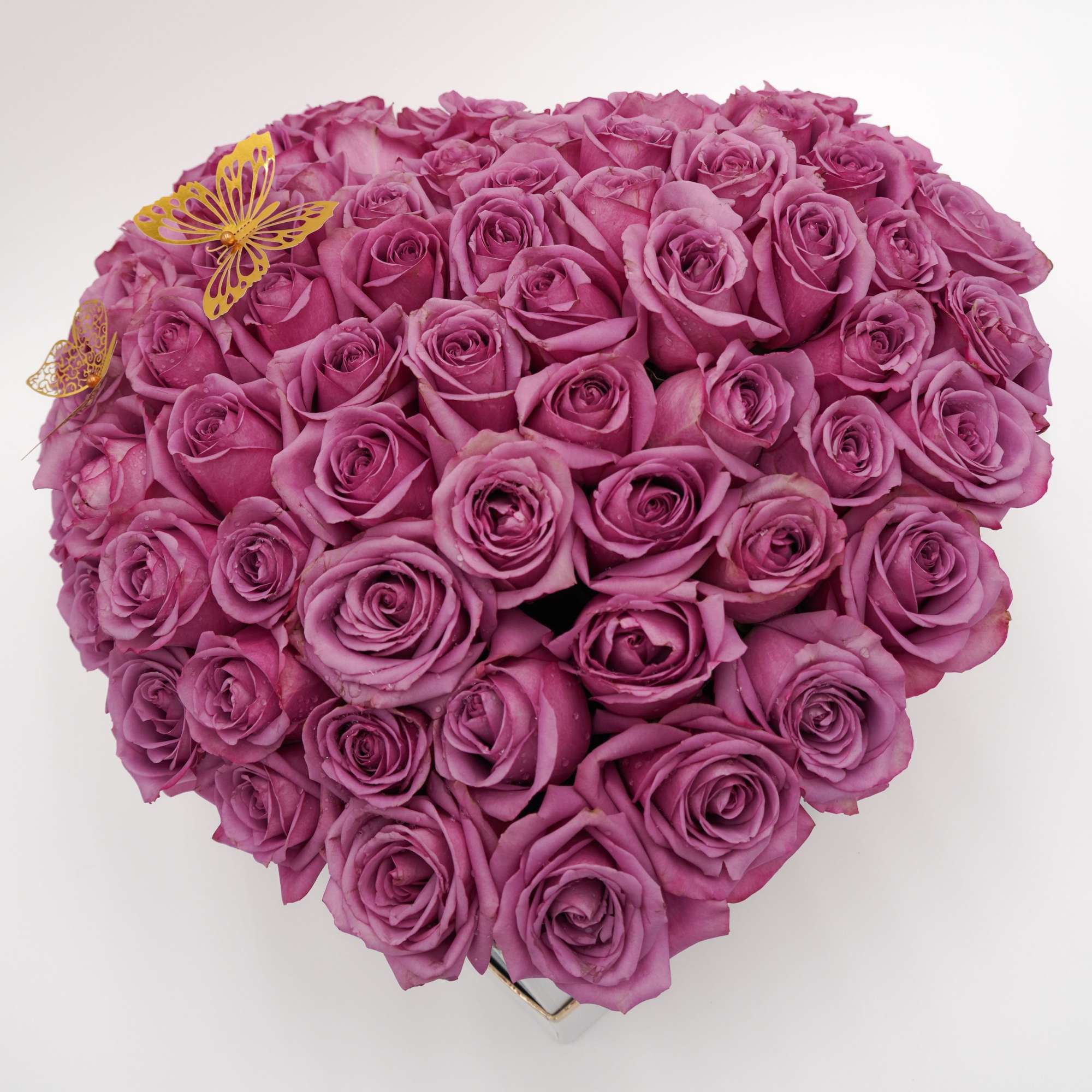 Heart-shaped bouquet of pink roses with small butterfly decorations
