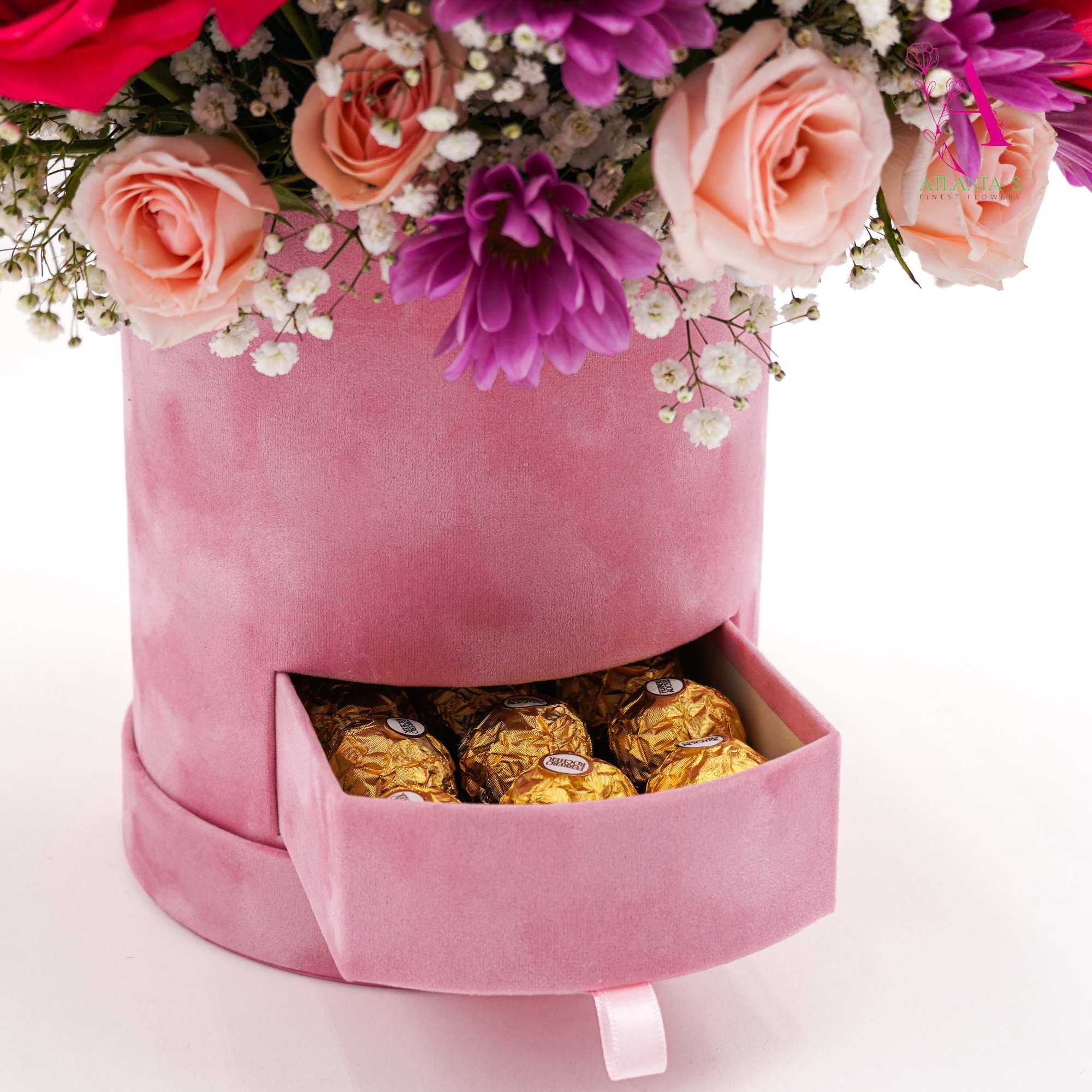 Pink flower box with roses, purple blooms, and chocolates in a drawer