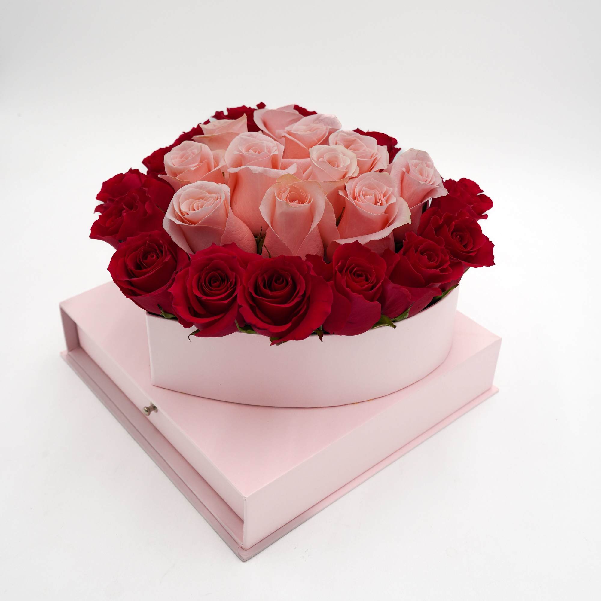 Pink and red roses arranged in a round pink box