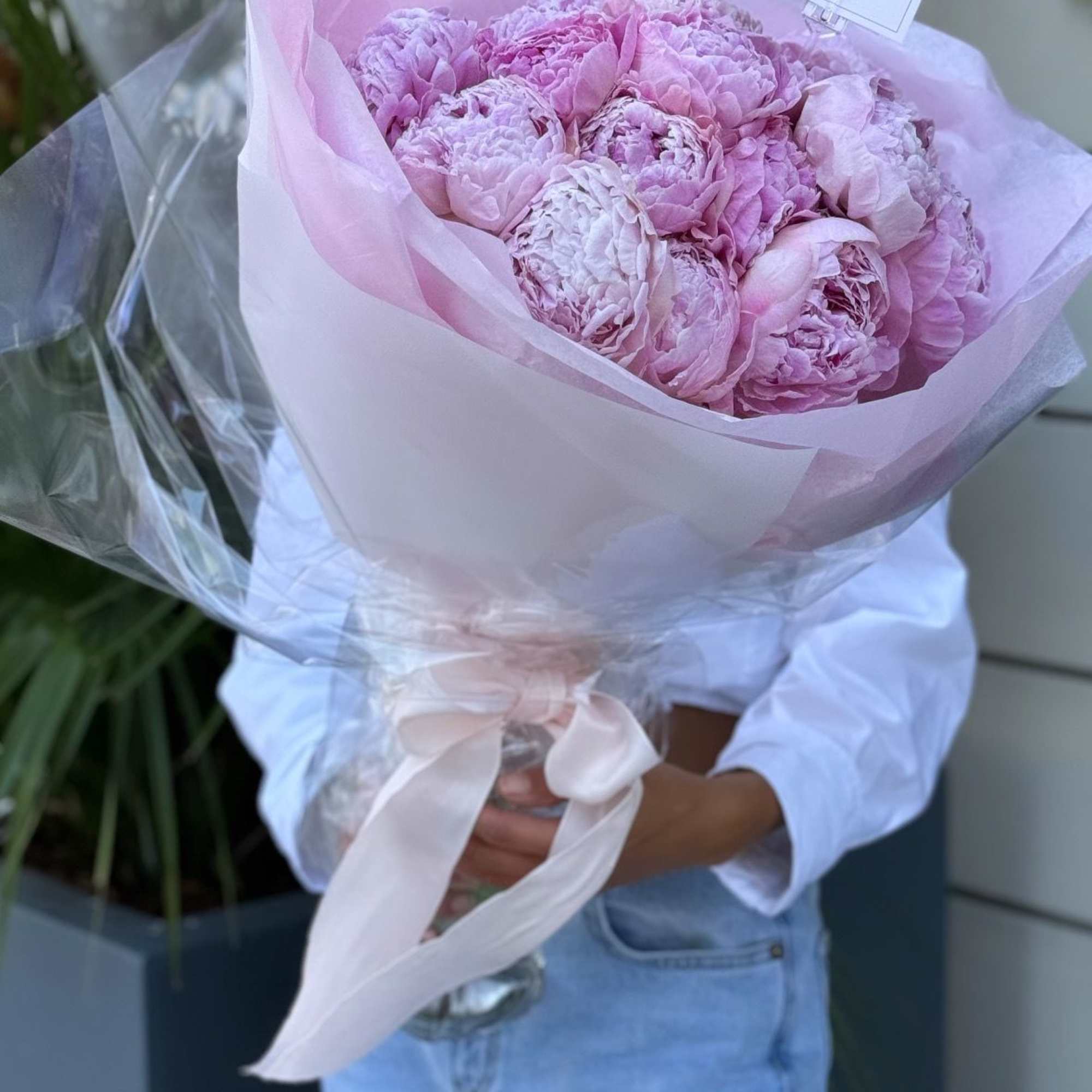 Bouquet of pink peonies wrapped in pale pink paper