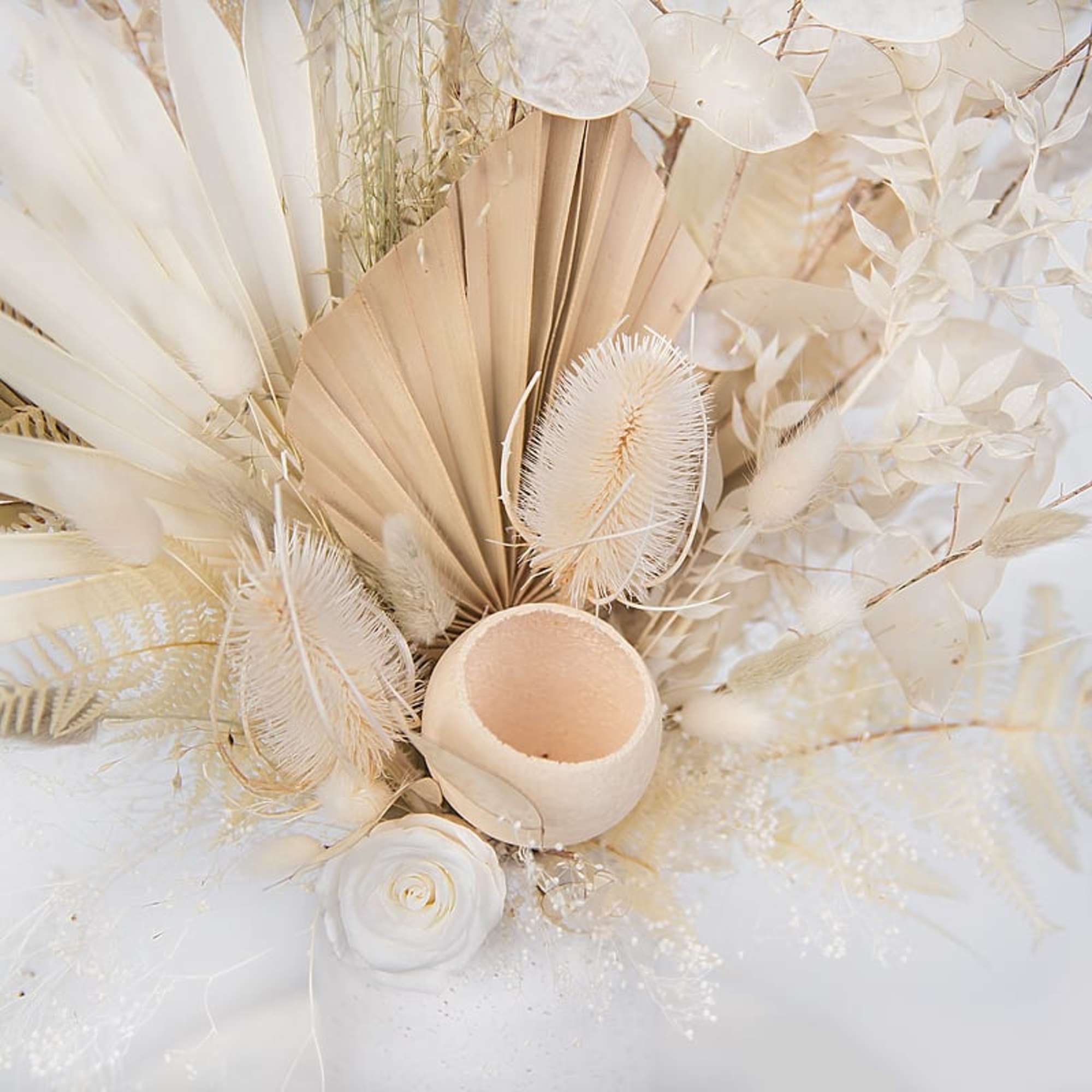 Cream and white dried floral arrangement with a small candle holder