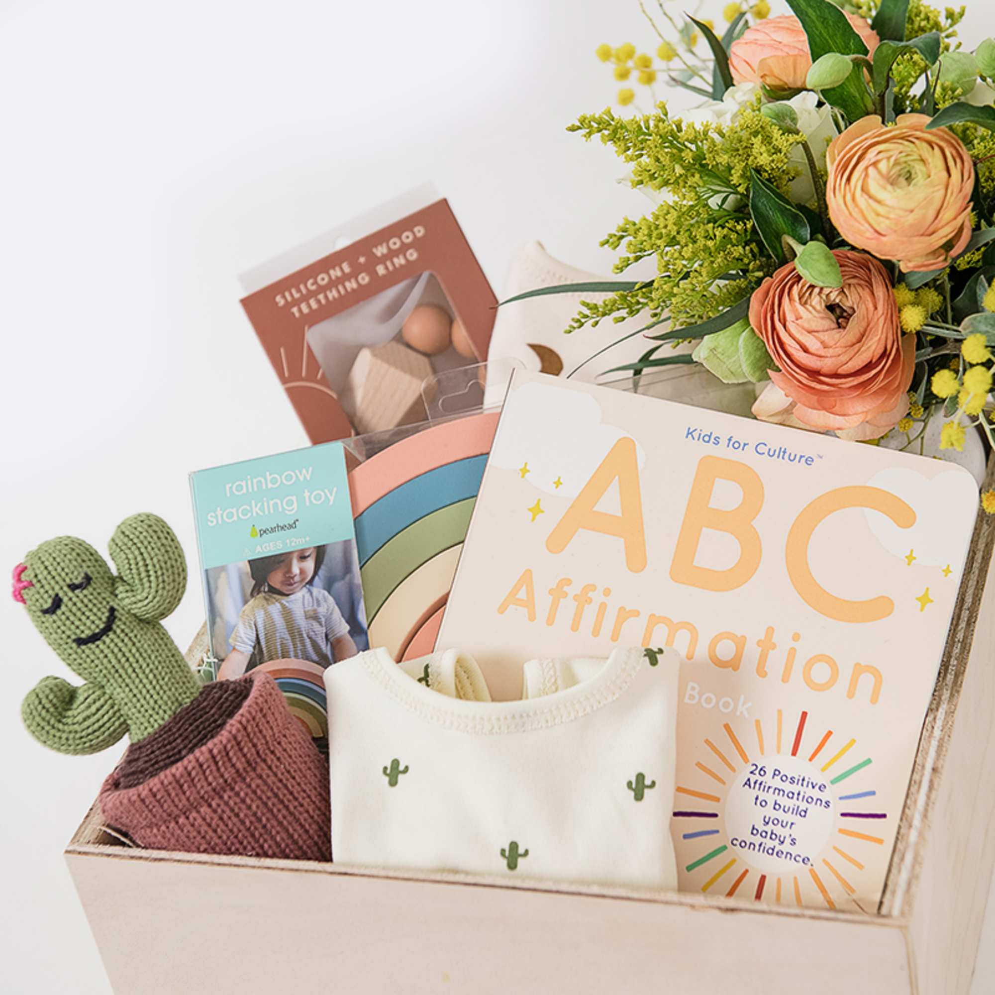 Gift box with baby toys, books, and a floral bouquet