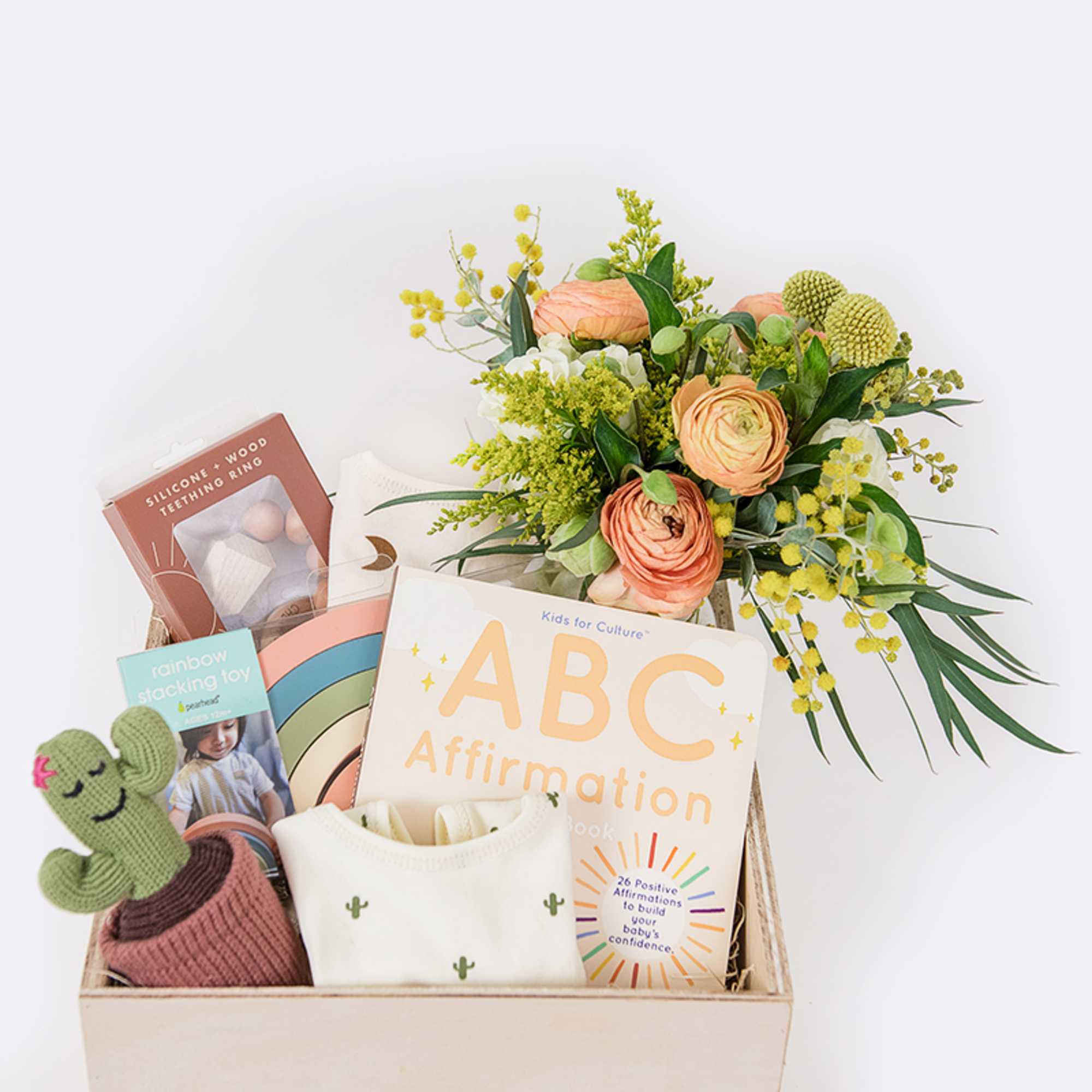 Gift basket with flowers, baby items, and books