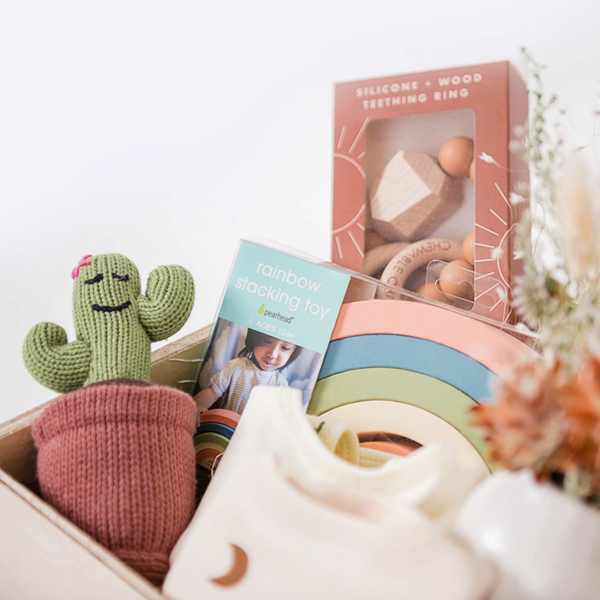 Gift basket with baby toys and a knitted cactus plush