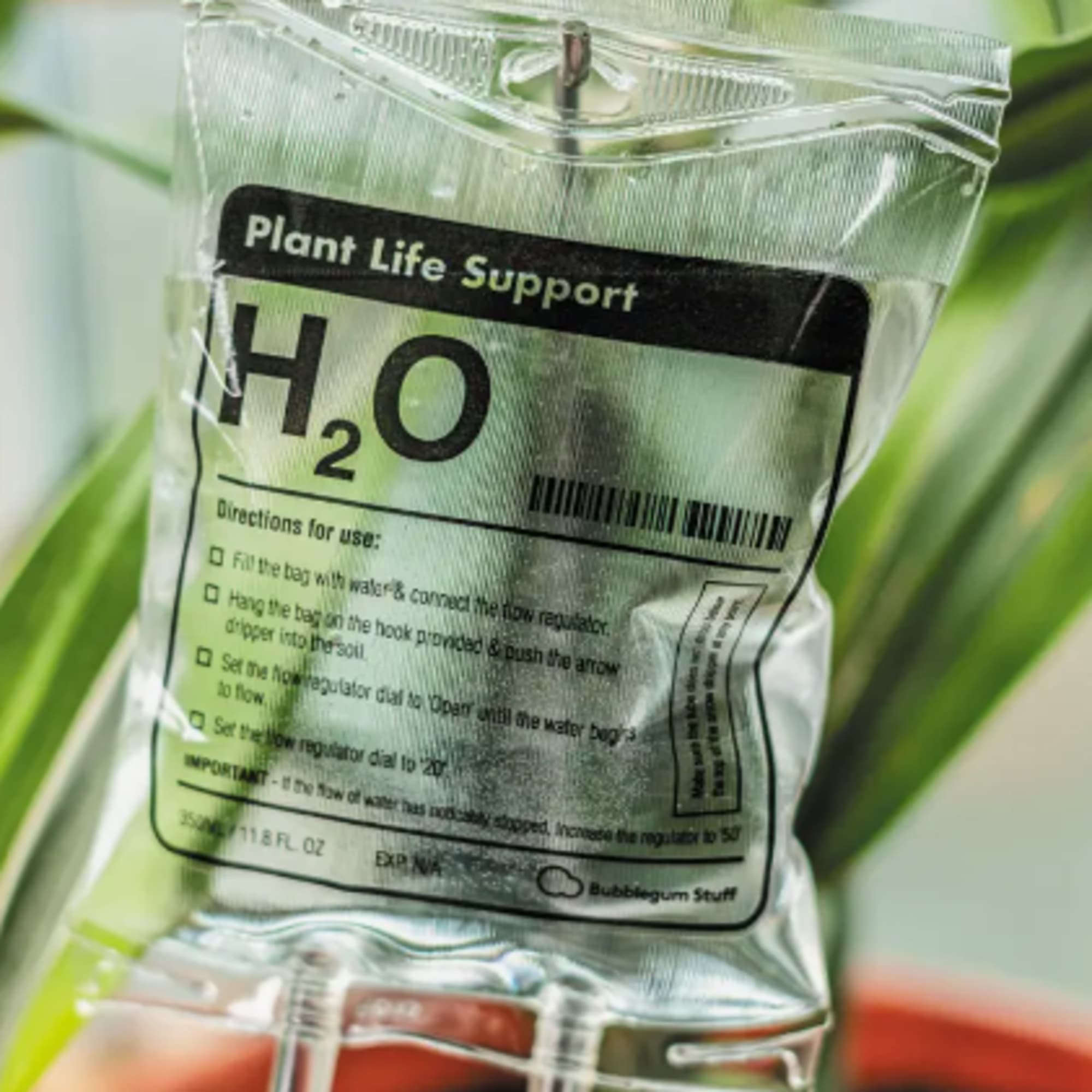 Plastic plant hydration bag labeled H2O hanging among flowers
