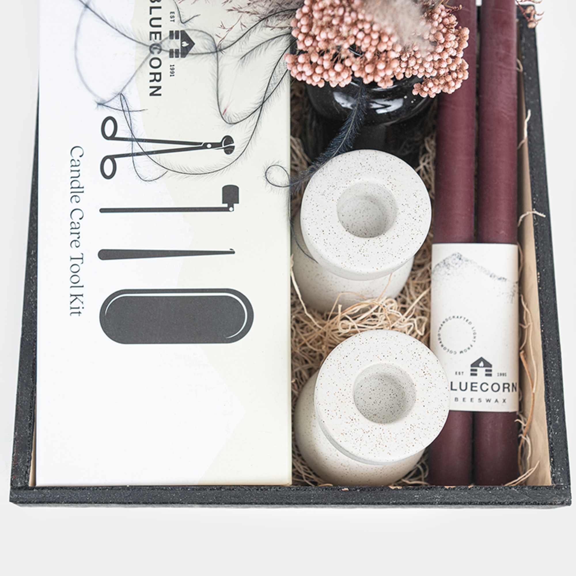 Candle care kit with burgundy taper candles and white accessories in a gift box