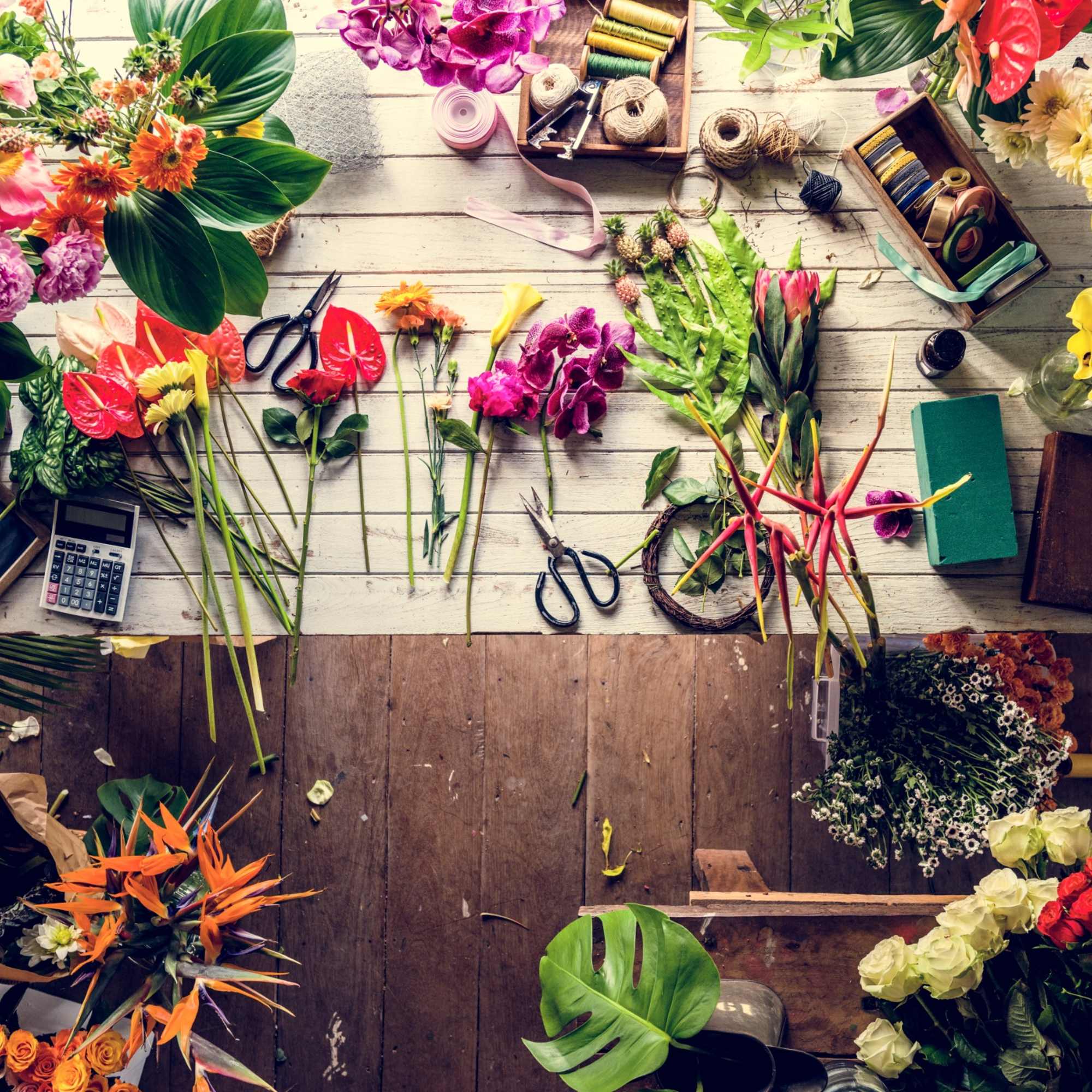 Assorted flowers and floral tools arranged on a worktable