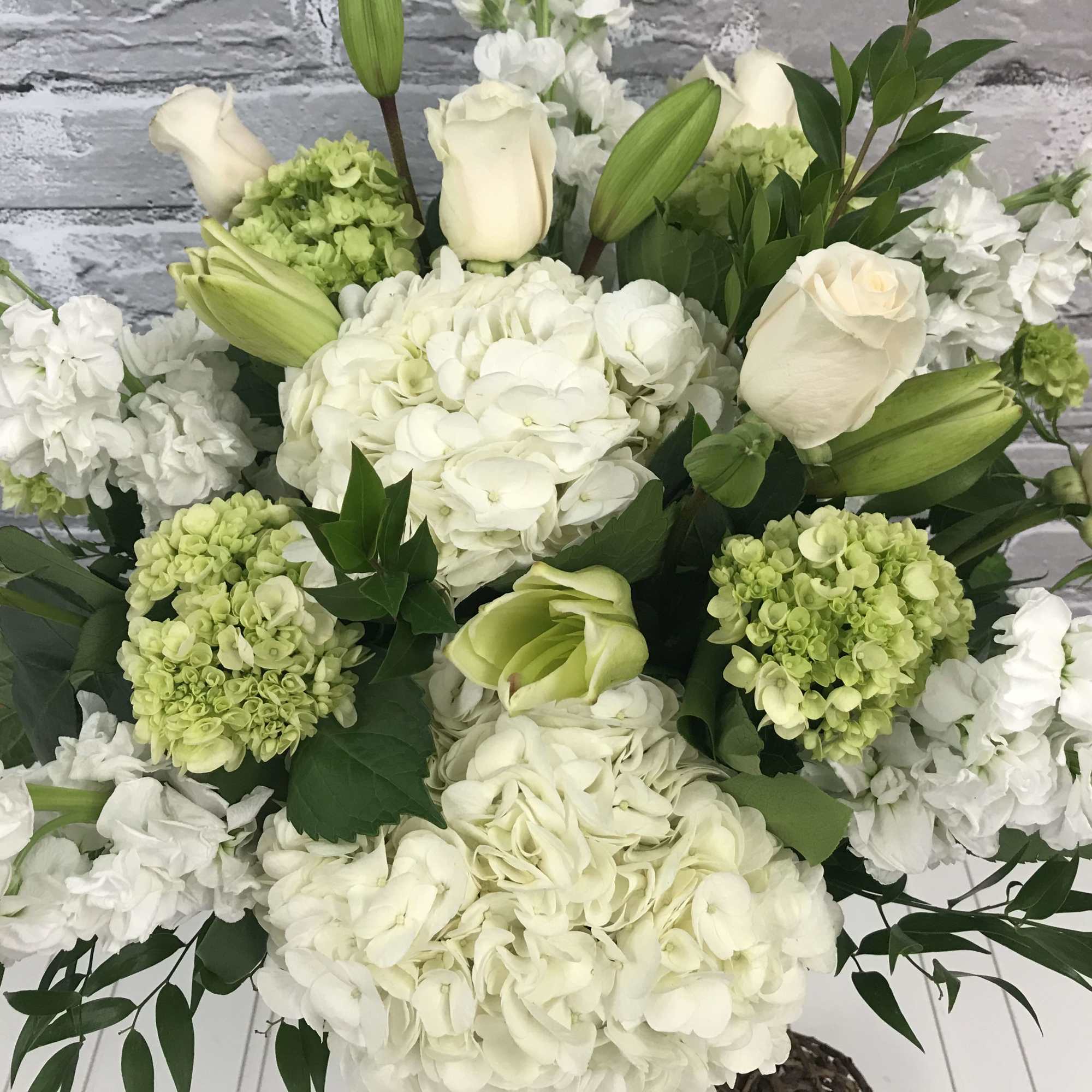 White and pale green floral arrangement with hydrangeas and lilies