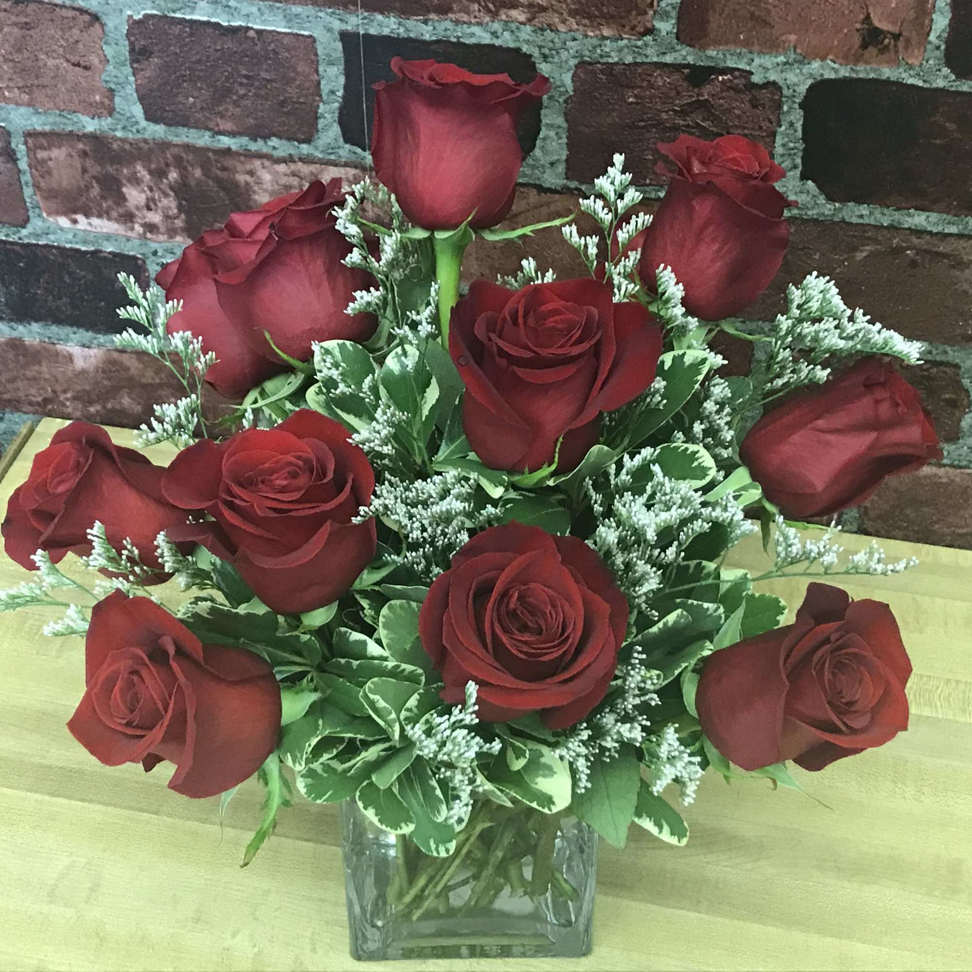 Red roses arranged in a clear glass vase