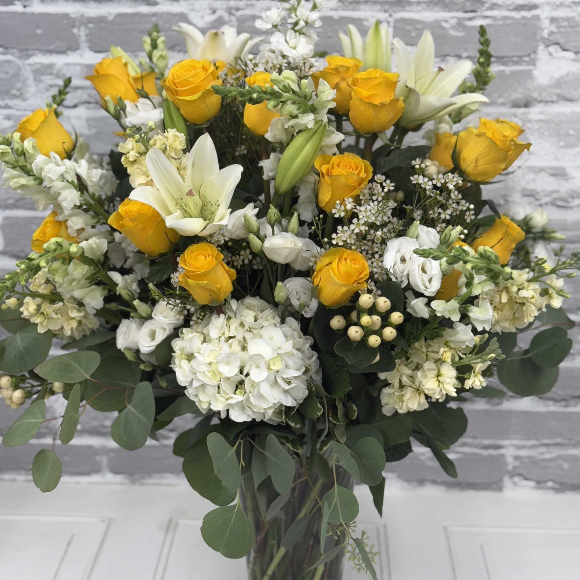 Yellow roses and white lilies in a glass vase, photo 3 of 3