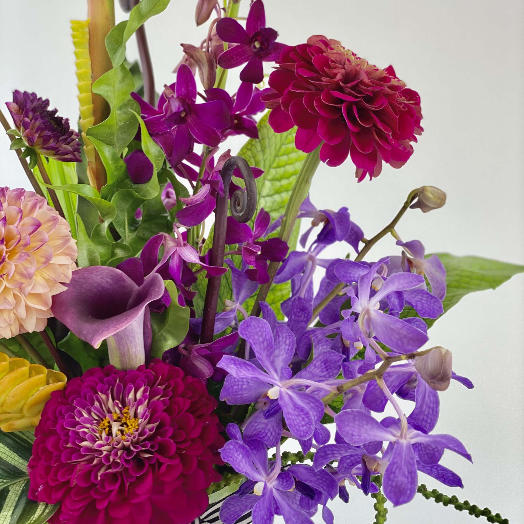Colorful bouquet with purple orchids, magenta dahlias, and a purple calla lily