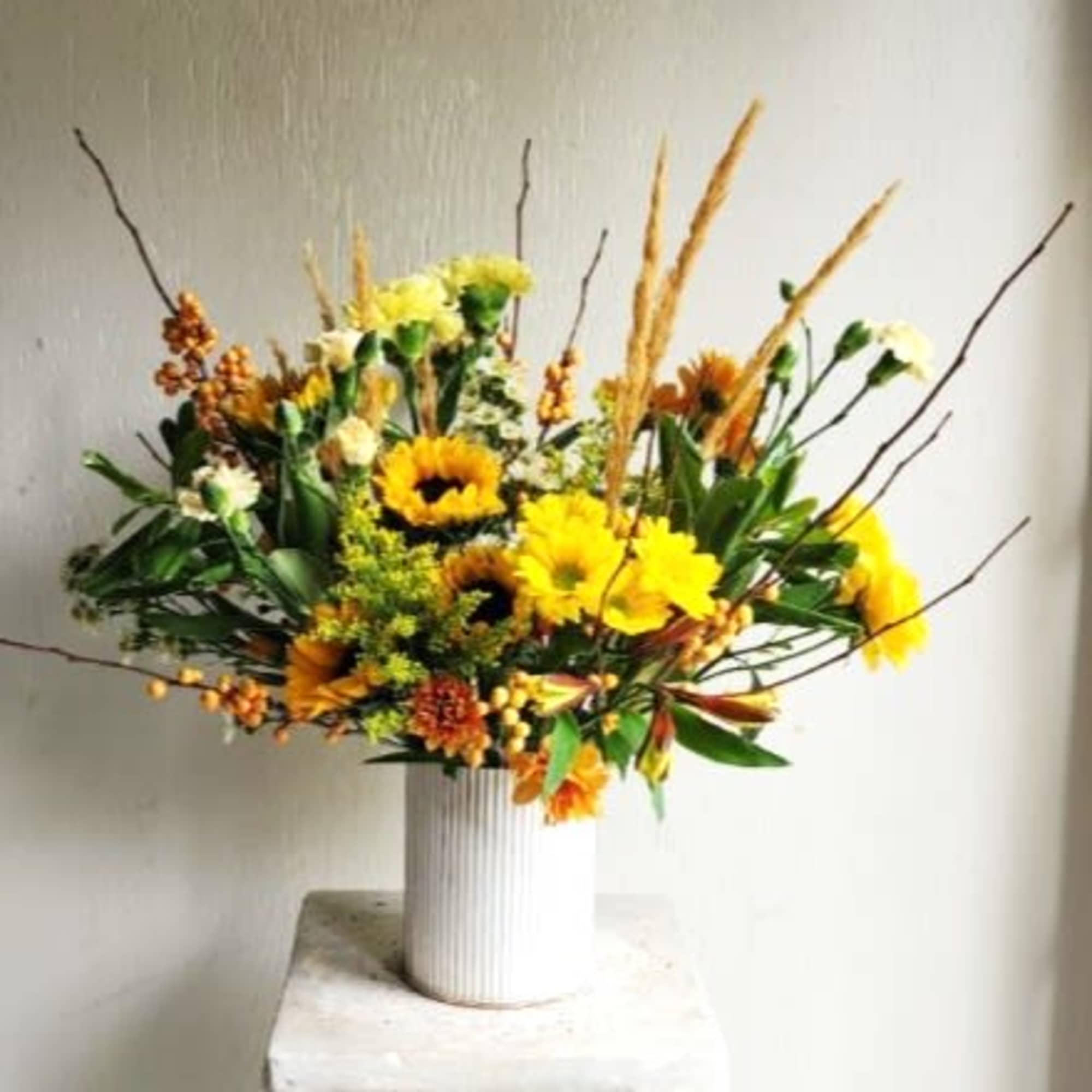 Yellow and orange floral arrangement in a white vase