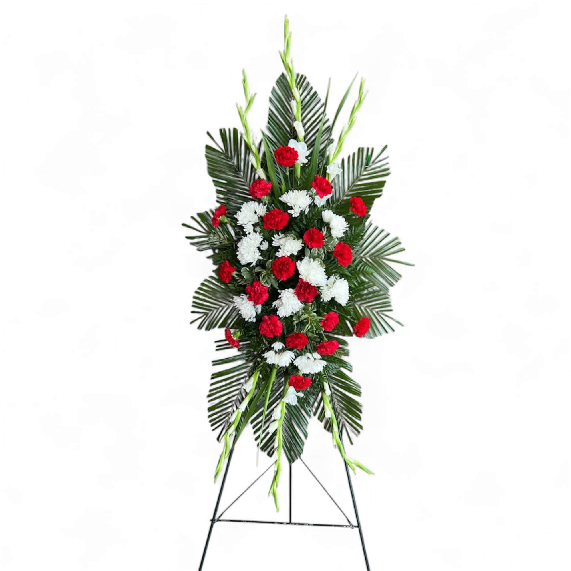 Standing floral spray with red and white flowers on a metal easel