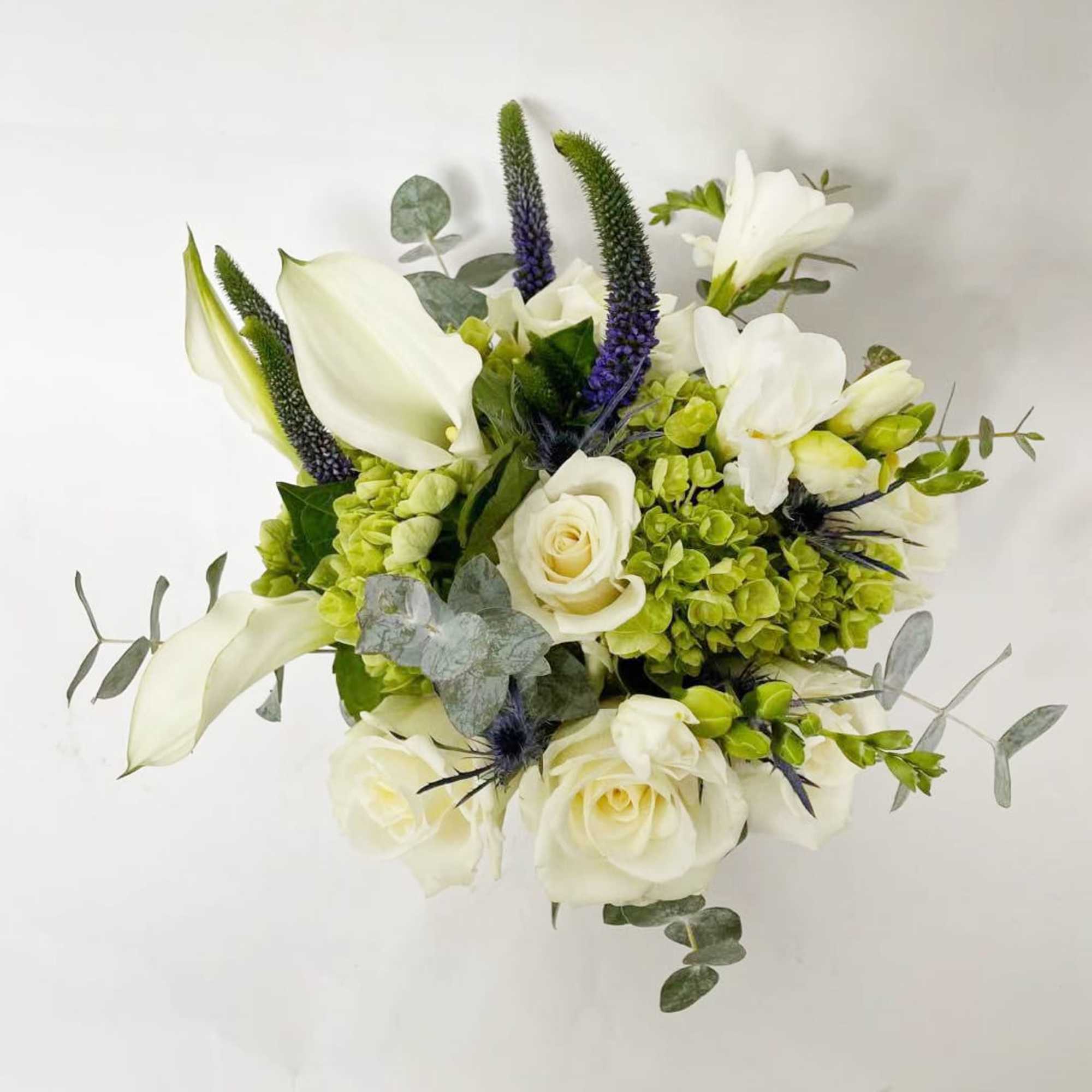 White roses and calla lilies with green hydrangeas in a bouquet