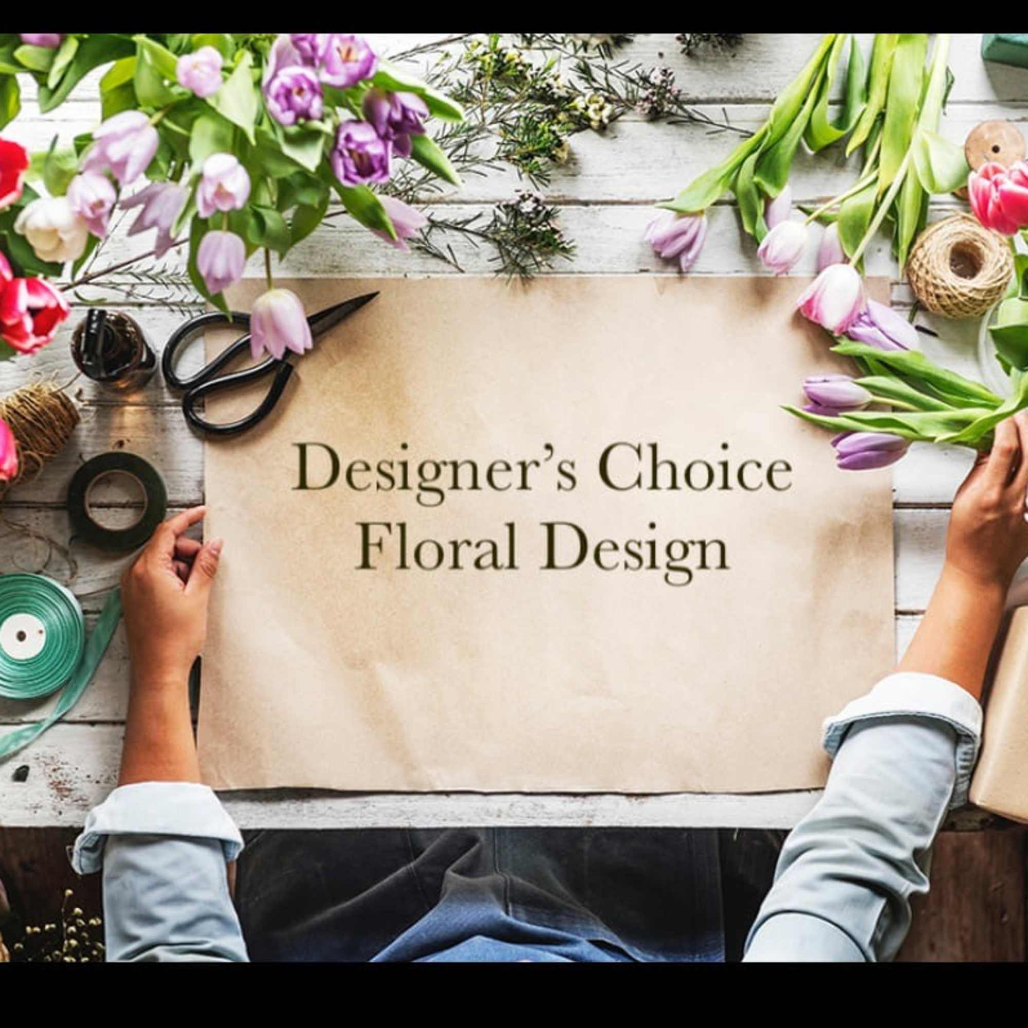 Flat lay of assorted tulips and floral supplies around a floral design sign