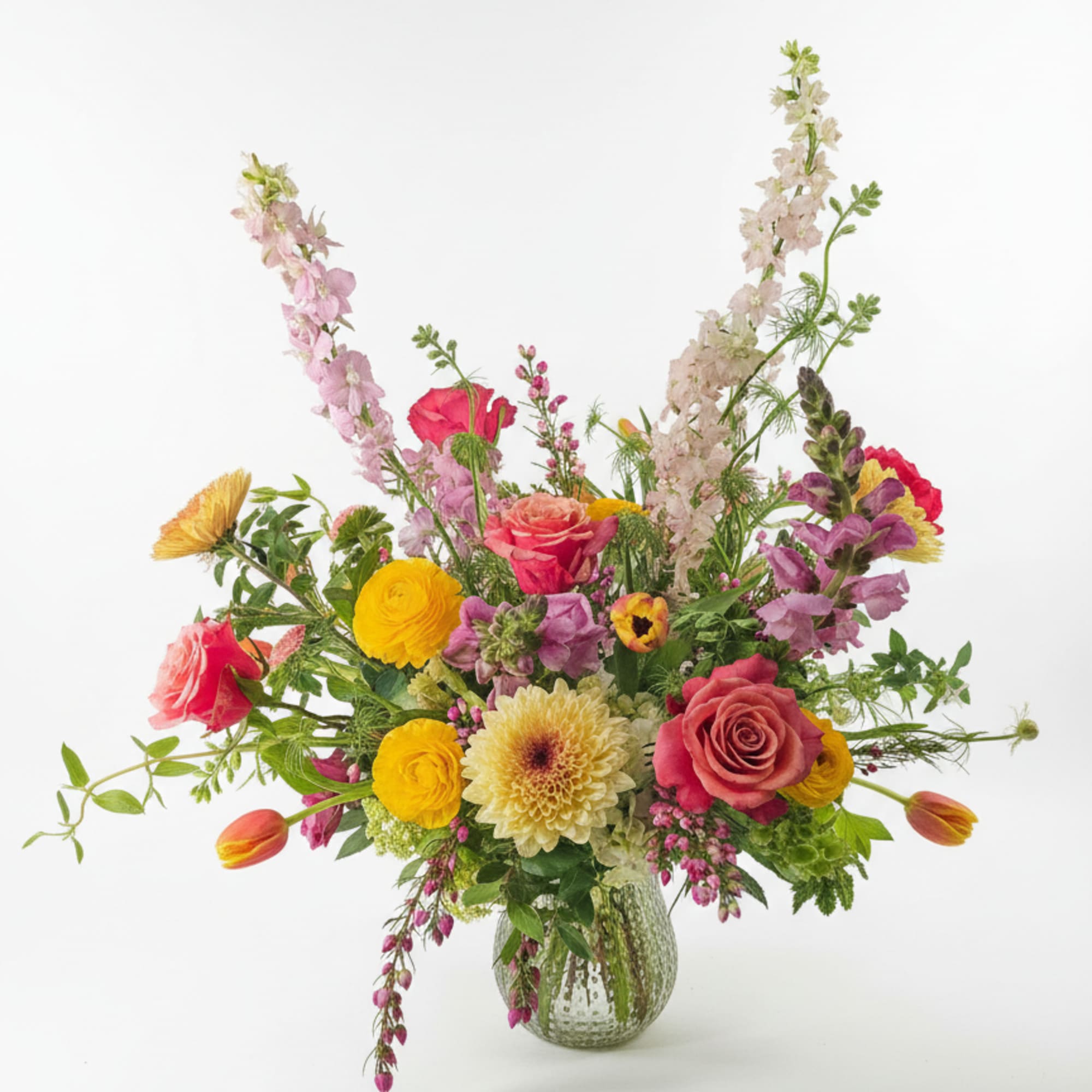 Luminous pink roses and cheerful yellow ranunculus mingle with peach tulips and, photo 2 of 2