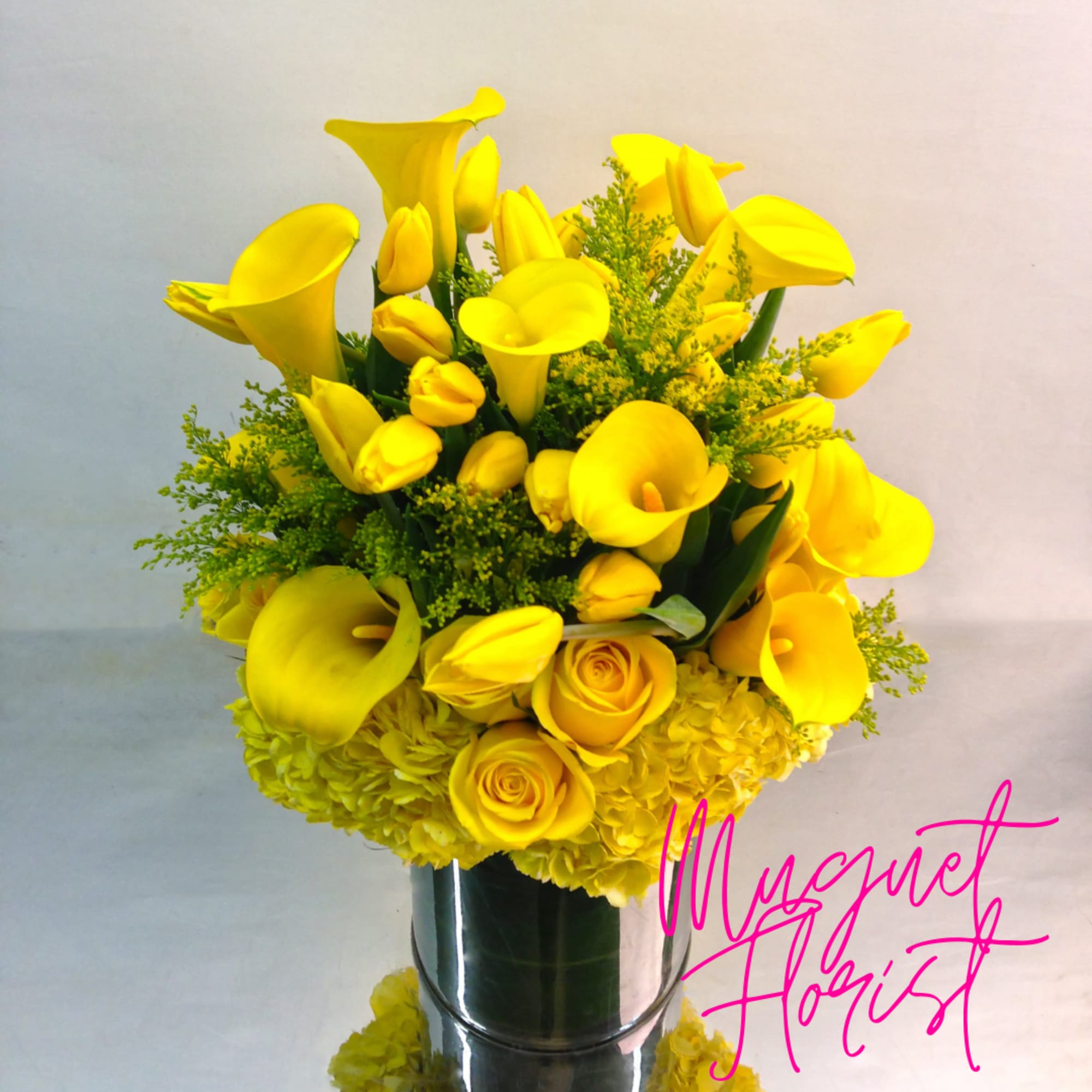 Yellow calla lilies and roses arranged in a silver vase, photo 2 of 3