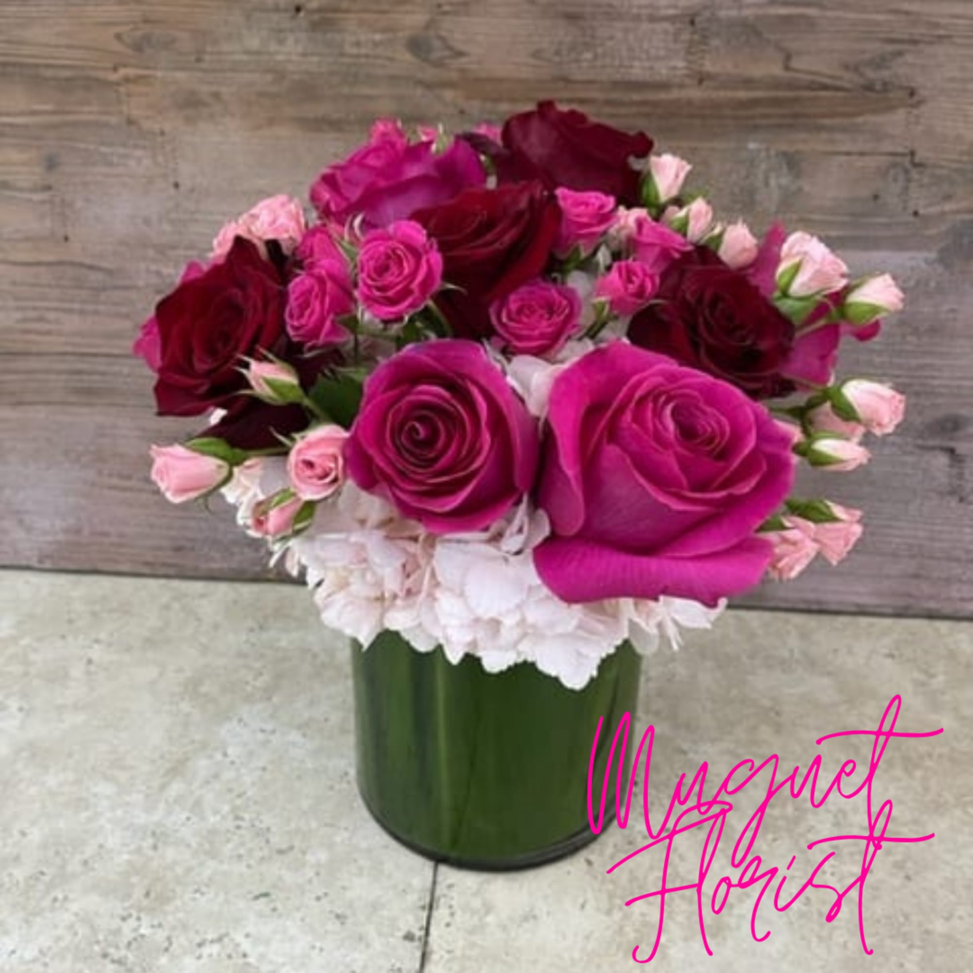 Pink and burgundy roses arranged in a green vase