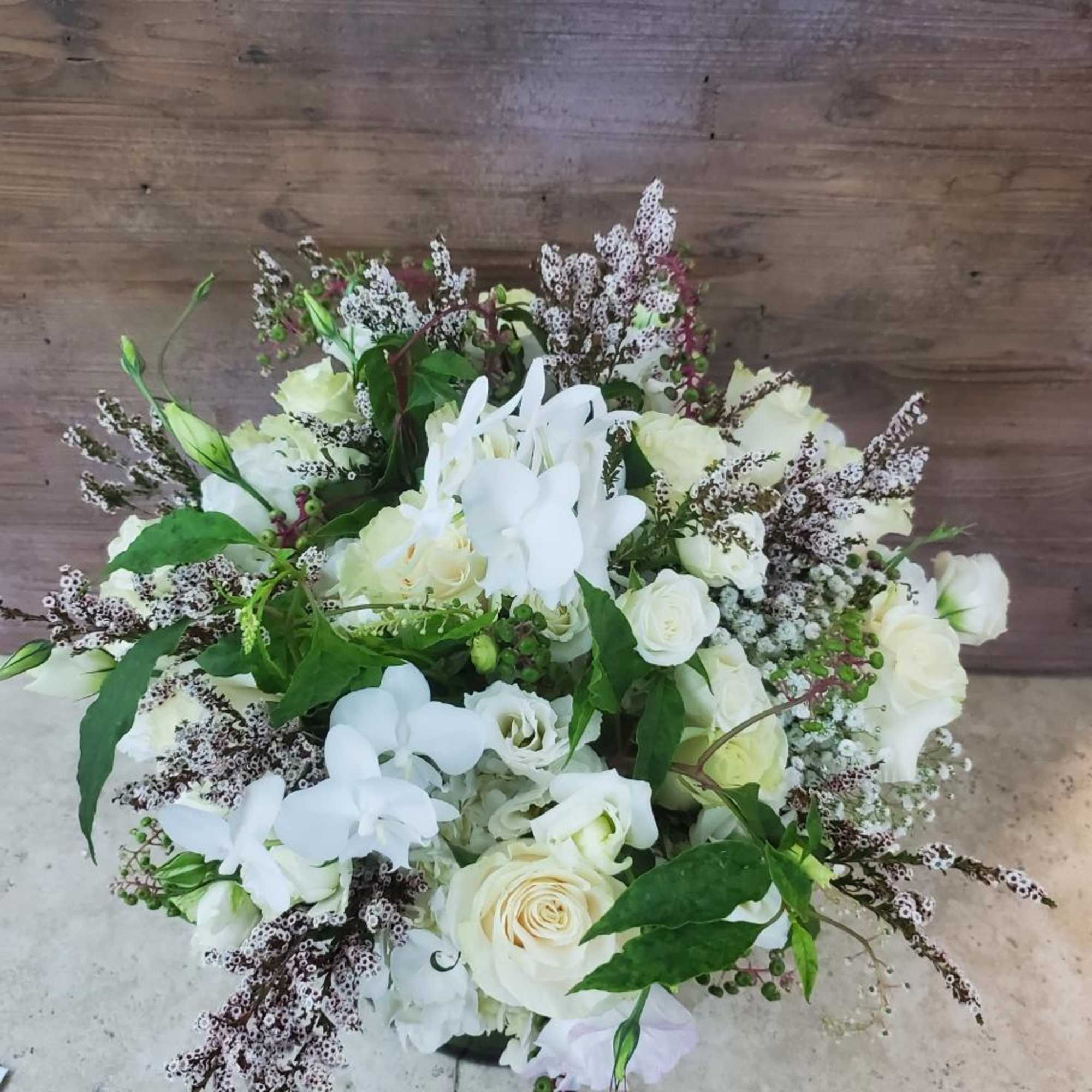 White roses and orchids arranged in a bouquet