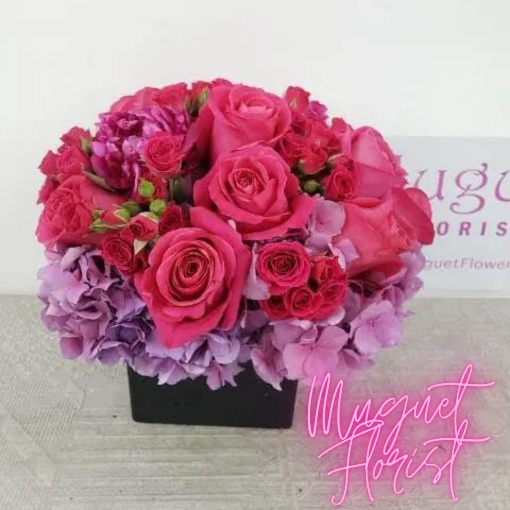 Pink roses and lavender hydrangeas in a black square vase
